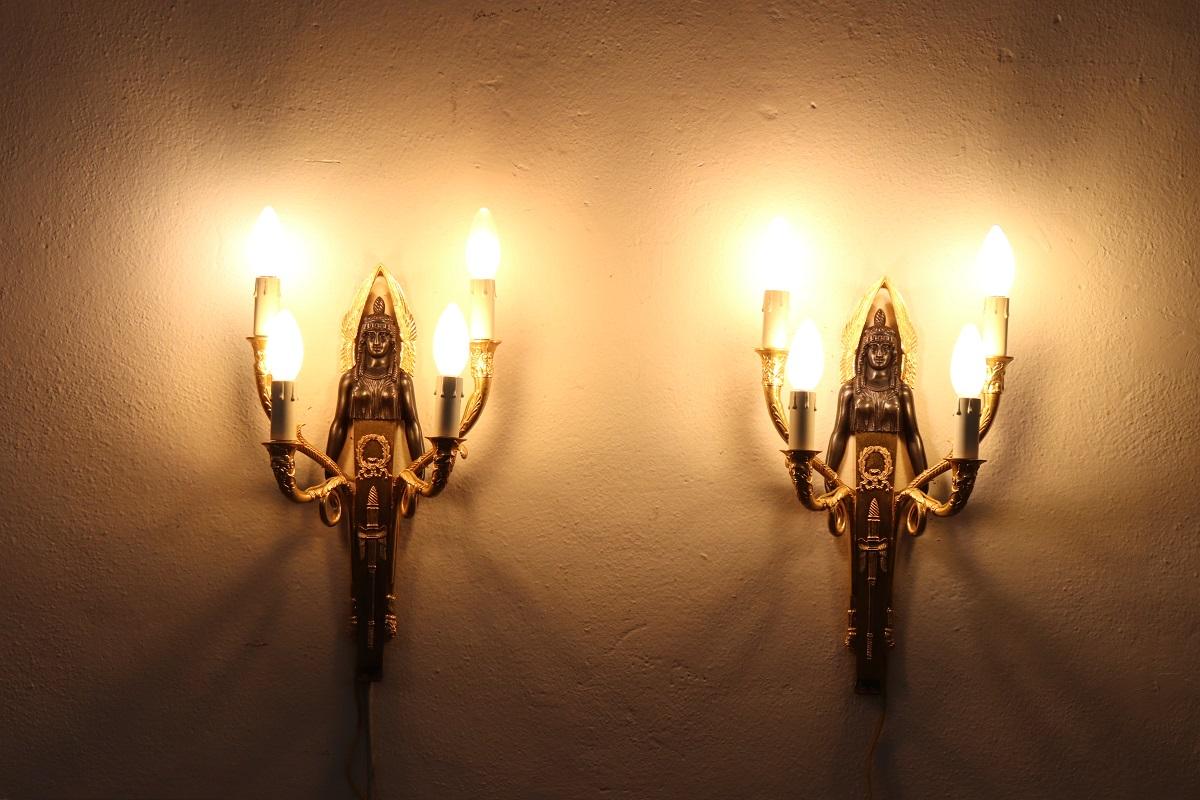 Beautiful and refined 20th century, 1970s circa, pair of wall lights or sconces with four lights each. Made of gilded and patinated bronze. The bronze is finely chiseled with elaborate decoration. Characterized by four arms in the shape of a