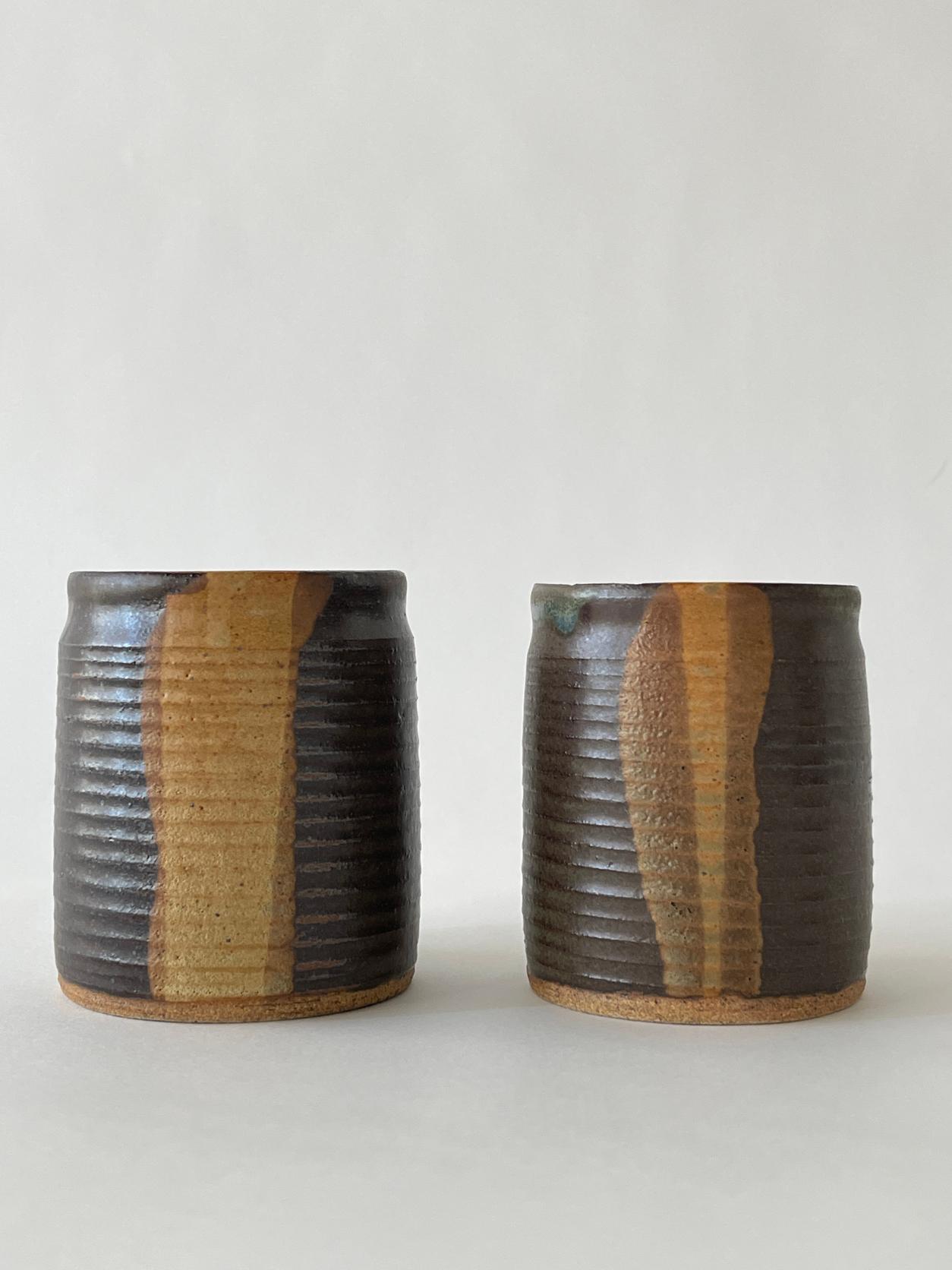 20th century Ridged ceramic cup set made in 1982. Beautiful ridged exterior with multi colored shades of brown throughout. 

Set of 2
Measures: 3.25