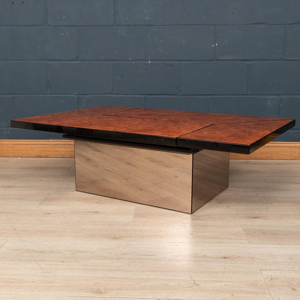 A stylish 1970s mid century coffee table and dry cocktail bar designed by Paul Michel for the luxury interiors brand Roche Bobois. An exotic wood veneer finishes the table top and pops out wonderfully against the mirrored glass base. The table opens