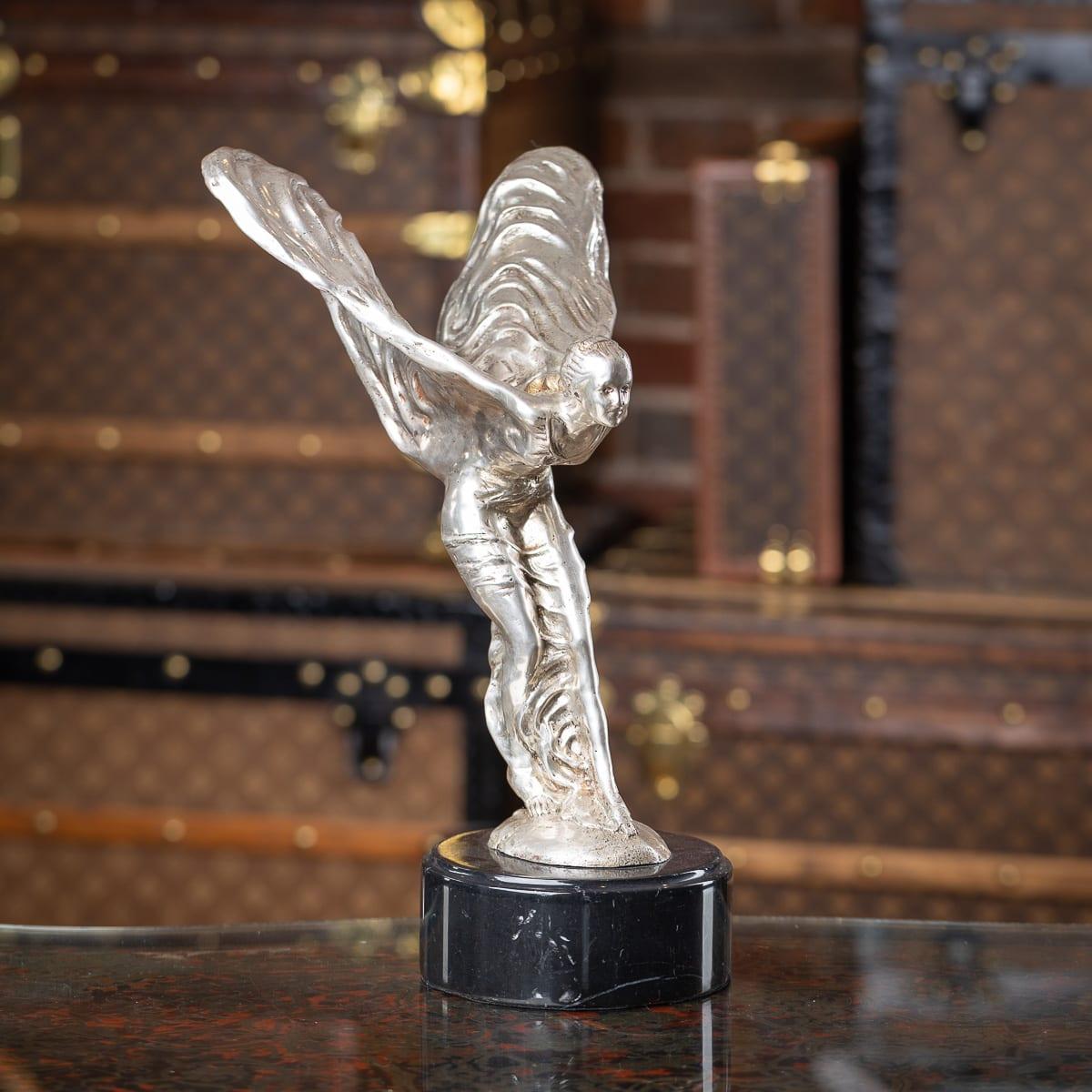 A 20th Century English silver plated model of the legendary Rolls-Royce mascot which was designed by Charles Sykes, this later cast silver plated statue stands on round marble plinth. The Spirit of Ecstasy, also called Eleanor, Silver Lady, or