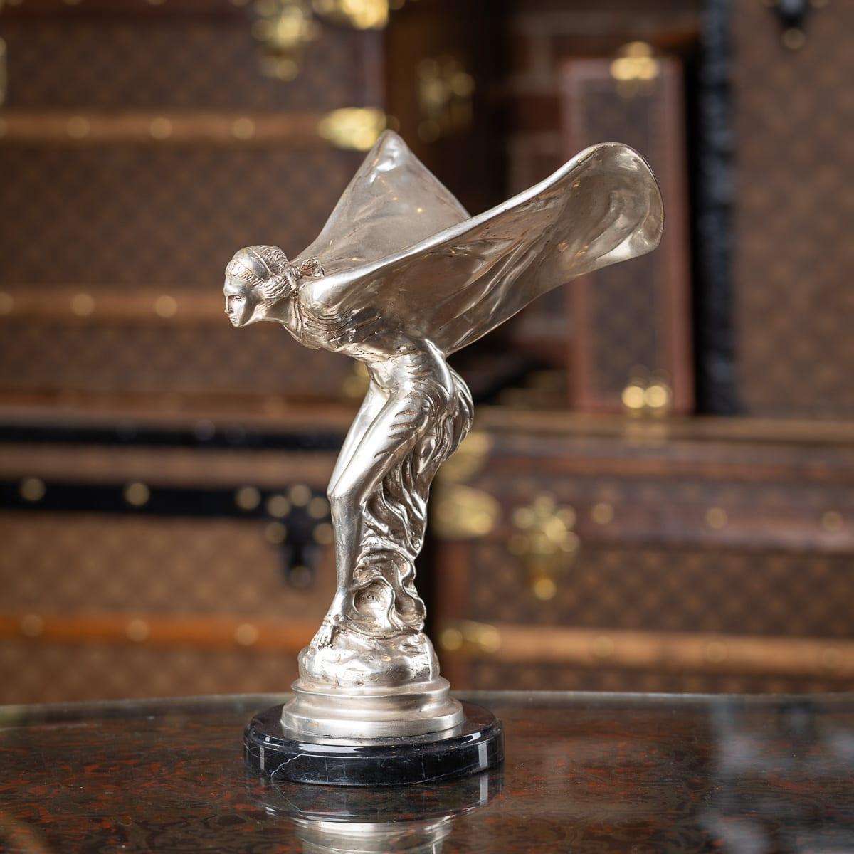 A 20th Century English silver plated model of the legendary Rolls-Royce mascot which was designed by Charles Sykes, this later cast silver plated statue stands on round marble plinth. The Spirit of Ecstasy, also called Eleanor, Silver Lady, or