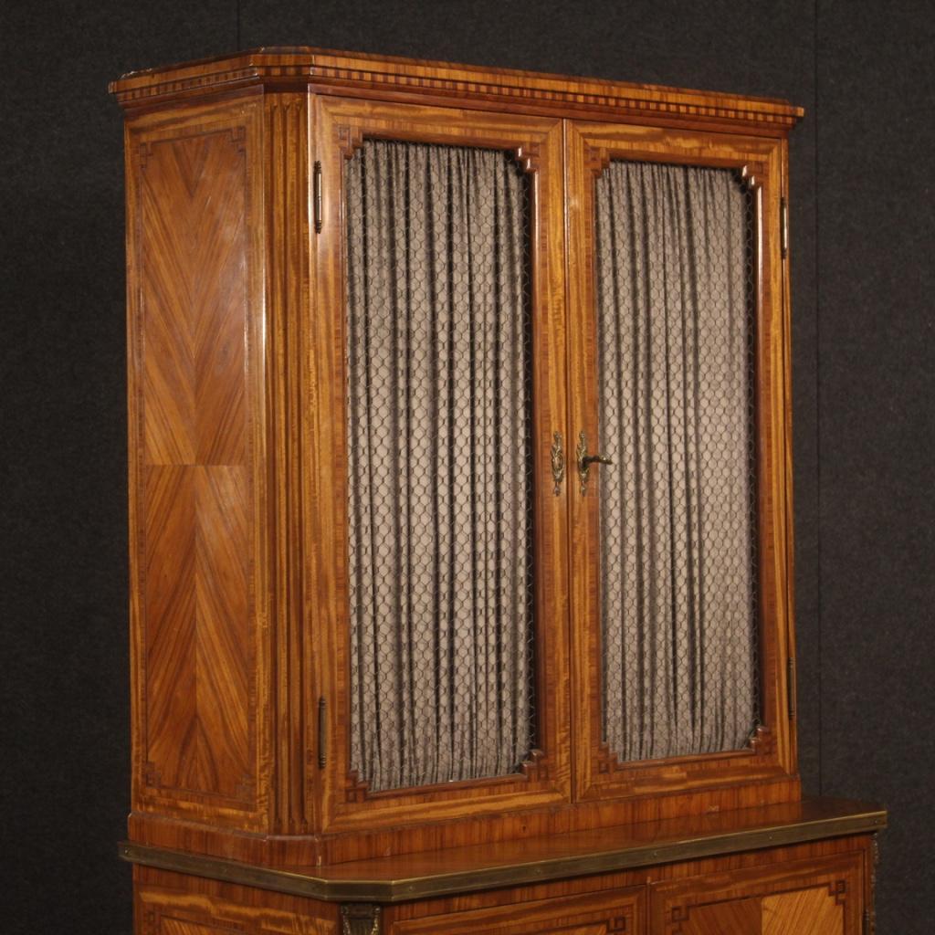 Small French bookcase from the early 20th century. Double-body inlaid furniture in rosewood, mahogany, maple, walnut and fruitwood. Sideboard with four doors, two of which are inlaid on the lower part and two with mesh and fabric on the upper body.