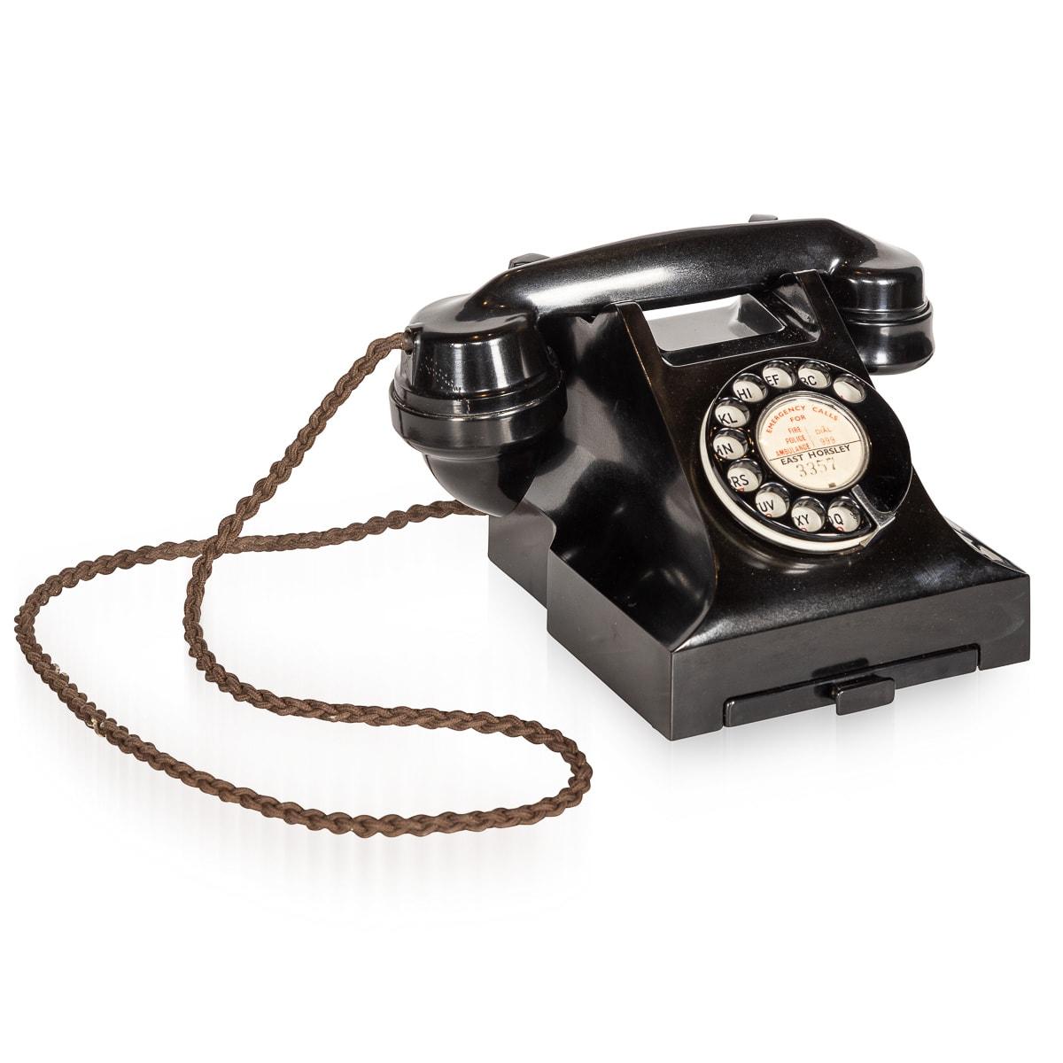 A superb and rare early 20th Century rotary Bakelite telephone. The phone features the original cord connecting handset to reciever and a small drawer at the front revealing a pad for telephone numbers. This device has been fully adapted to work