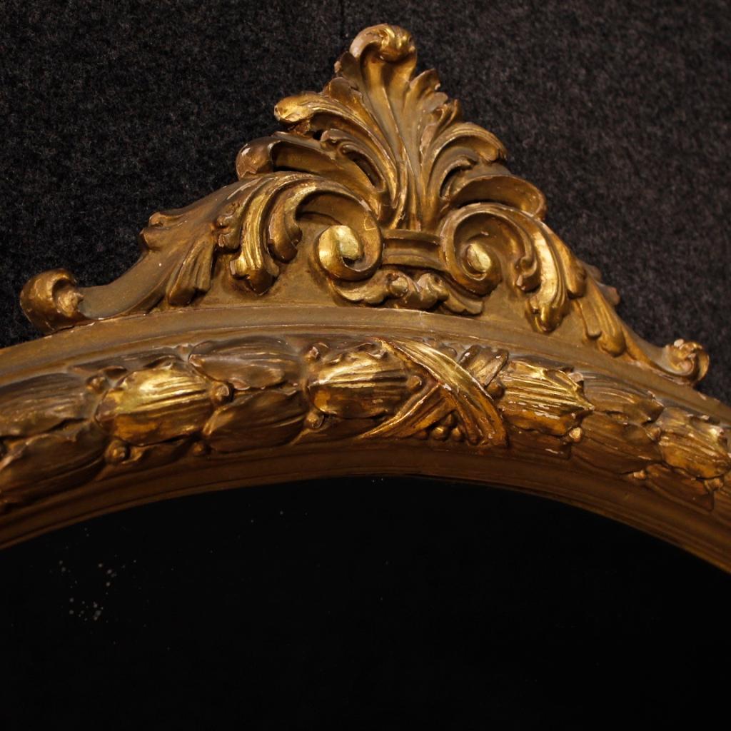 Italian mirror from the mid-20th century. Finely carved and gilded wooden furniture of fabulous decor. Round mirror adorned with four small side moulding. Furniture of excellent proportion that can be easily placed in different points of the house.