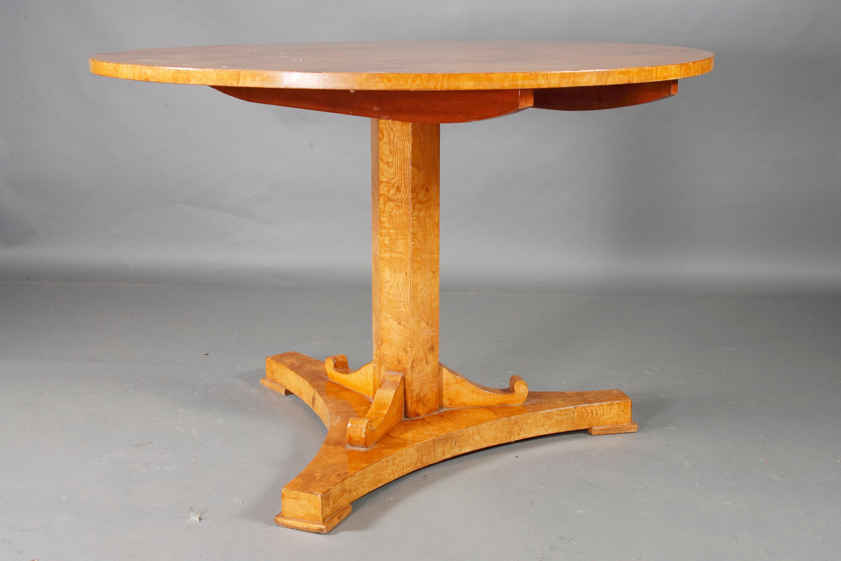 Maple root veneer on solid wood. Three-sided retracted base plate on disc feet. Inclined, eight-sided columned column, flanked by three curly volutes. A strict form of the early Biedermeier period. He is equipped with a folding mechanism. This type