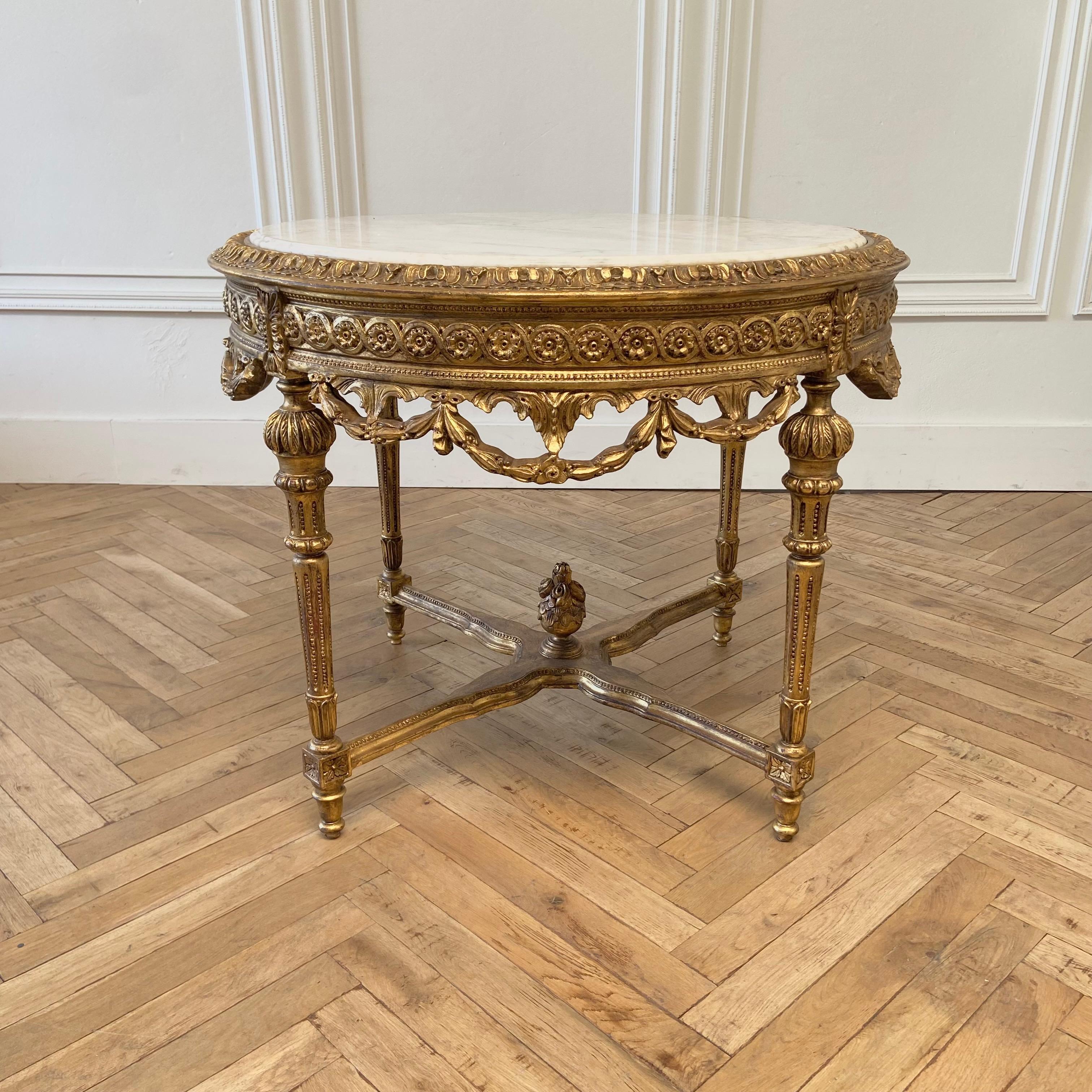 20th century round gilt wood center table with white marble top
Size:
40” rd. X 32”h
This table is a vintage reproduction of an antique Louis XVI Style, it is a gilt wood finish, with solid strong construction. The white marble top has grey and