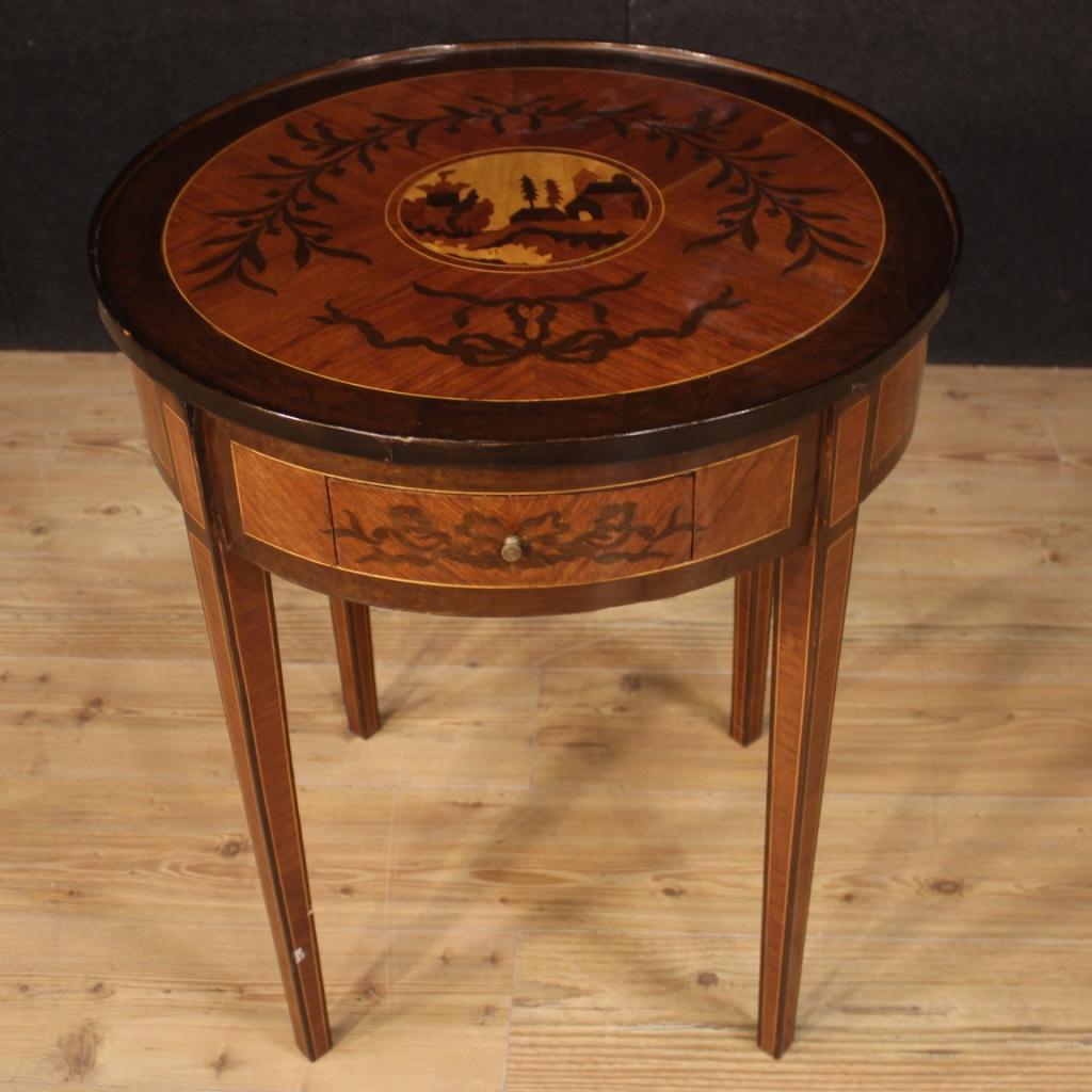 Elegant Italian 20th century side table. Louis XVI style furniture inlaid in walnut, rosewood, mahogany, maple and fruitwood. Round side table that offers a wooden top in character with central inlay depicting landscape. Furniture equipped with a