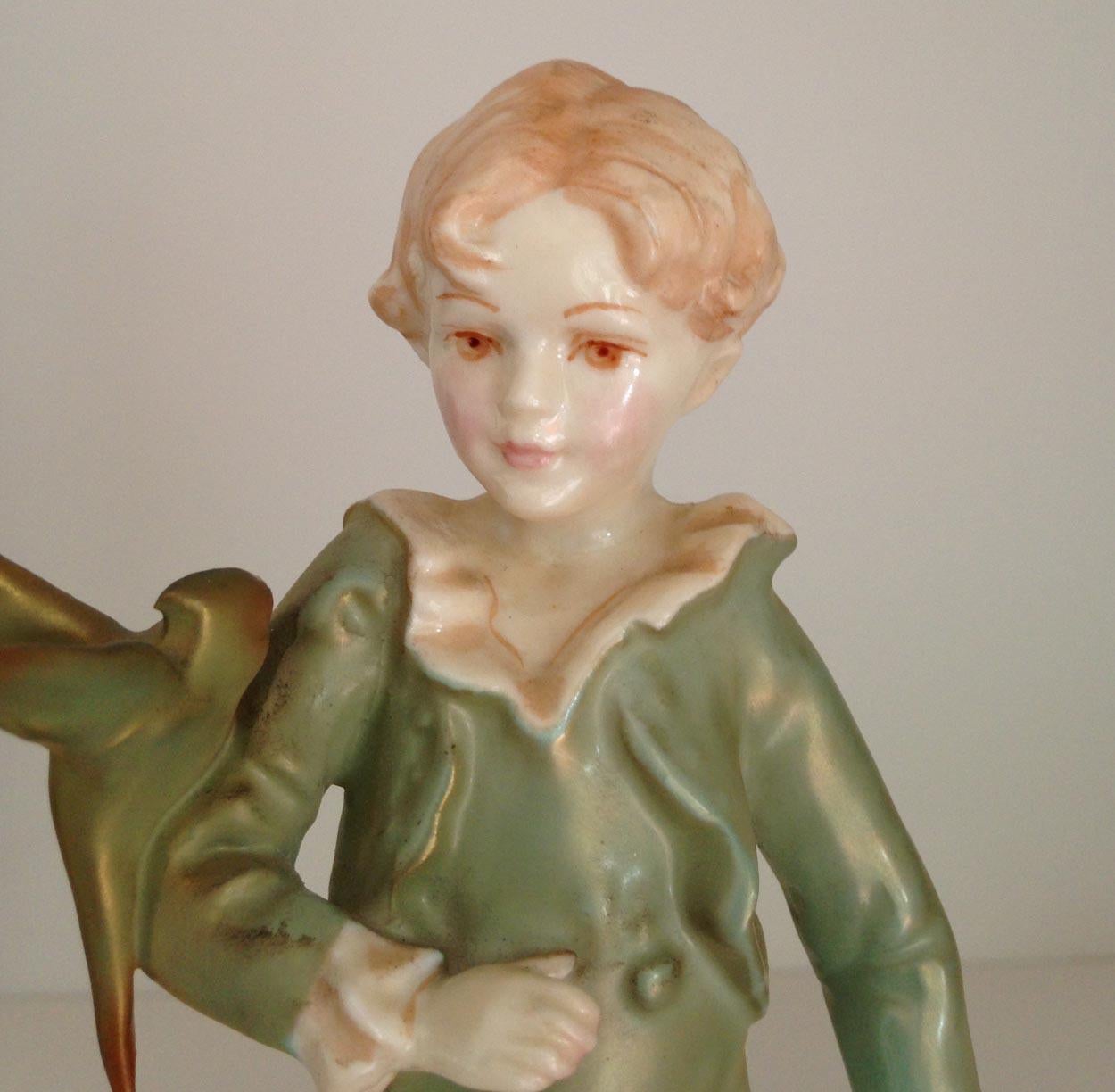 Royal Worcester figurine parakeet boy, made in England. The figurine depicts a young boy with a parakeet perched on his right arm. The boy is dressed in a green jacket and breeches and shoes with buckles.

This design was modeled by the Royal