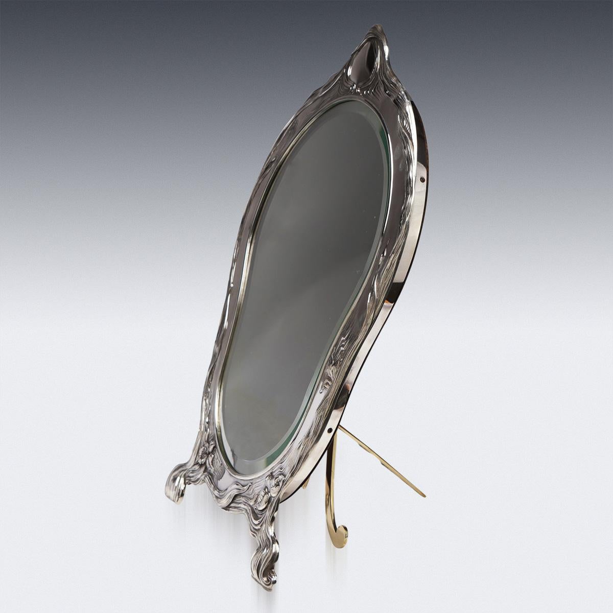 Antique early-20th Century Russian Art Nouveau solid silver large table mirror, delicately decorated with flowing flowers and foliage, vacant cartouche above. The mirror is mahogany backed and resting on an adjustable strut. Hallmarked Russian