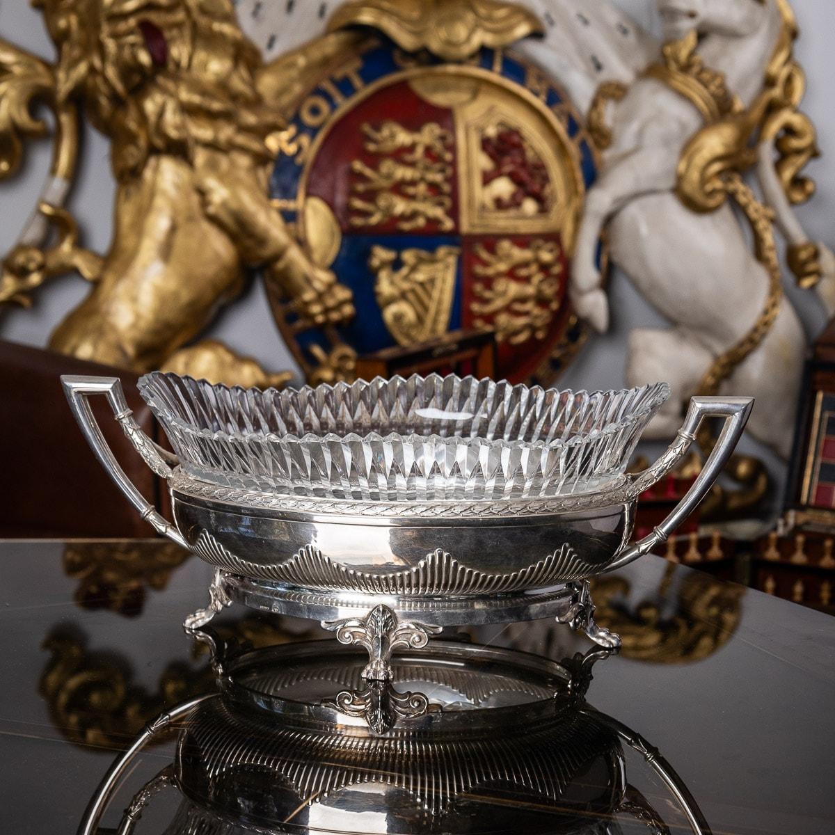 Antique early 20th century Russian Empire style solid silver and cut glass jardinière, oval shaped and mounted with geometrical twin handles, boarders embellished with laurel leaves and half fluted design along the base, standing on four leaf capped