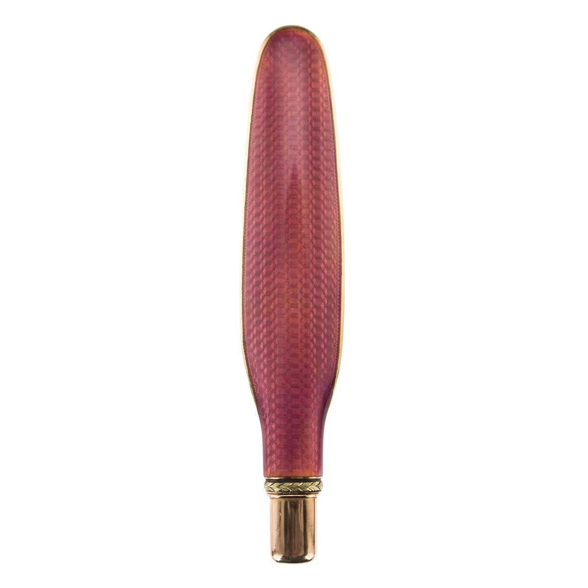 Antique early 20th century Imperial Russian Faberge gold and pink guilloche enamel pencil holder and letter opener, of flattened elongated-oval form, enameled in vibrant translucent pink over a wavy engine turned ground. Hallmarked Russian 56 gold