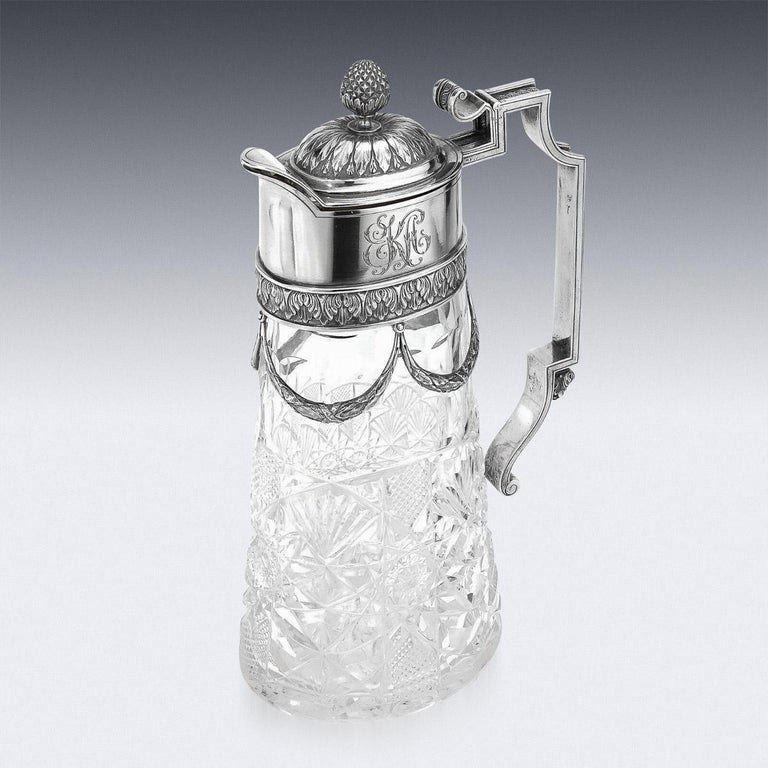 20th century Imperial Russian silver & cut glass claret jug, of oval tapering from with hob-nail cut-glass body, the mounts embossed with acanthus leaves and applied with suspended laurel garlands, applied with a shaped cast handle, hinged cover