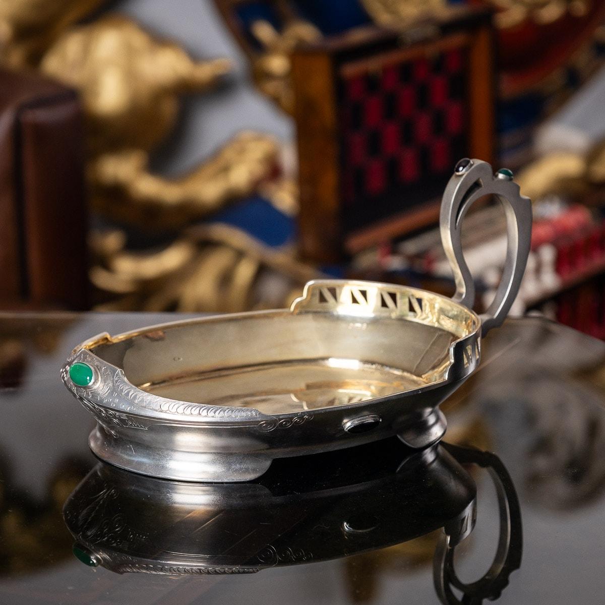 20th century Imperial Russian Pan Slavic style silver and gem set kovsh, applied with emeralds and garnet cabochons and the matted body mounted with an elaborately designed Pan-Slavic handle and a wide shaped stand, richly gilt interior. Hallmarked