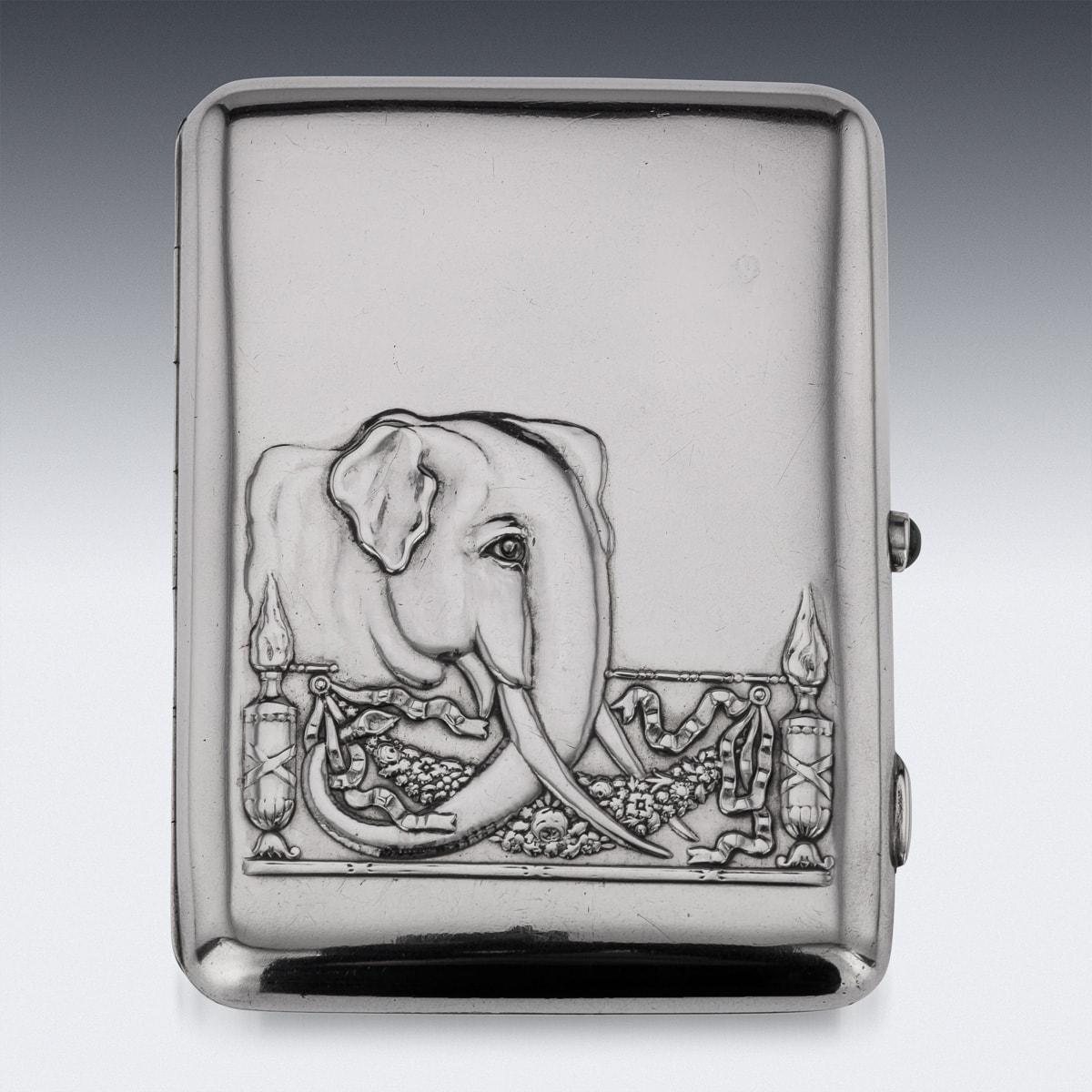 Antique late 19th Century Imperial Russian solid silver cigarette case, with richly parcel gilt interior, of rectangular form with curved corners, the hinged cover beautifully decorated depicting an elephant behind a stylized empire style fence,