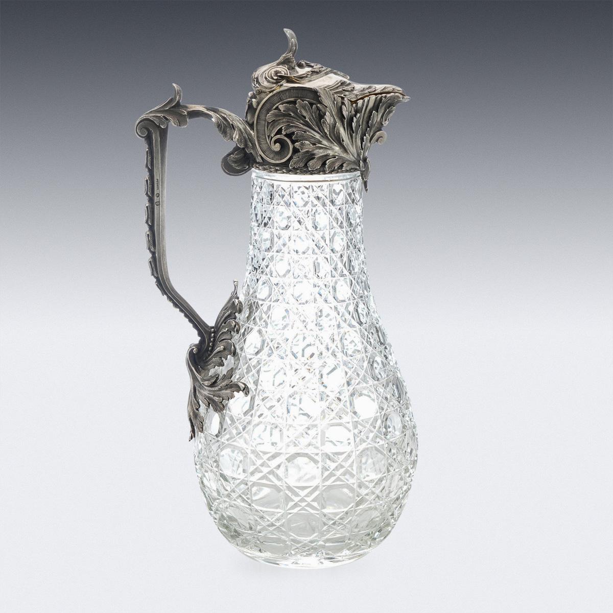 20th century Imperial Russian solid silver & cut glass claret jug, of baluster from with hob-nail cut-glass body, the mounts embossed with acanthus leaves and scrolls, applied with a shaped cast leaf-capped handle, hinged cover mounted with an leaf