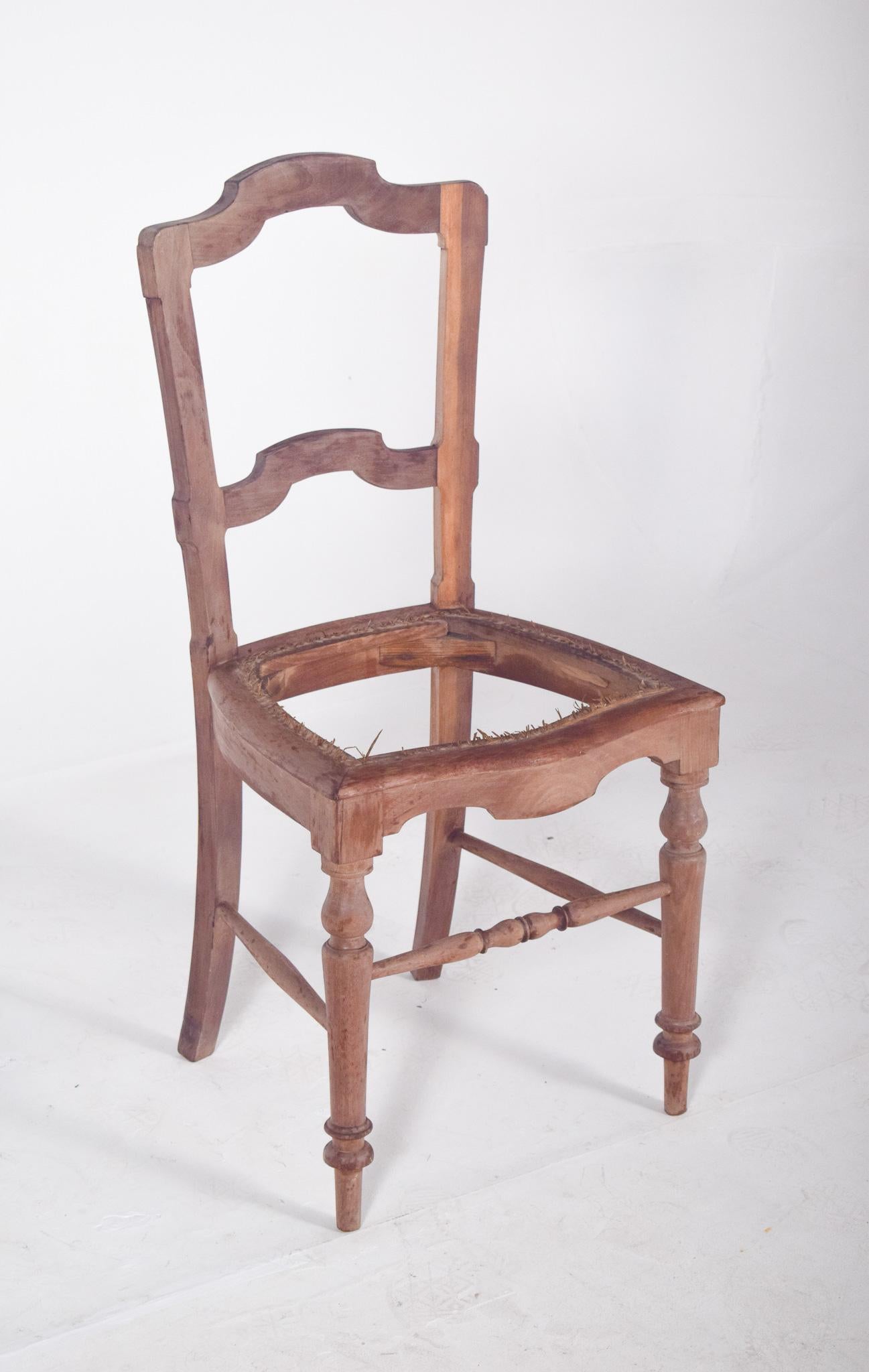 Chaise rustique antique, sans assise. Style traditionnel, avec un dossier découpé dans une silhouette incurvée et des doubles échancrures horizontales, qui ajoutent du caractère et de l'élégance. Les pieds avant sont tournés, ce qui contraste avec