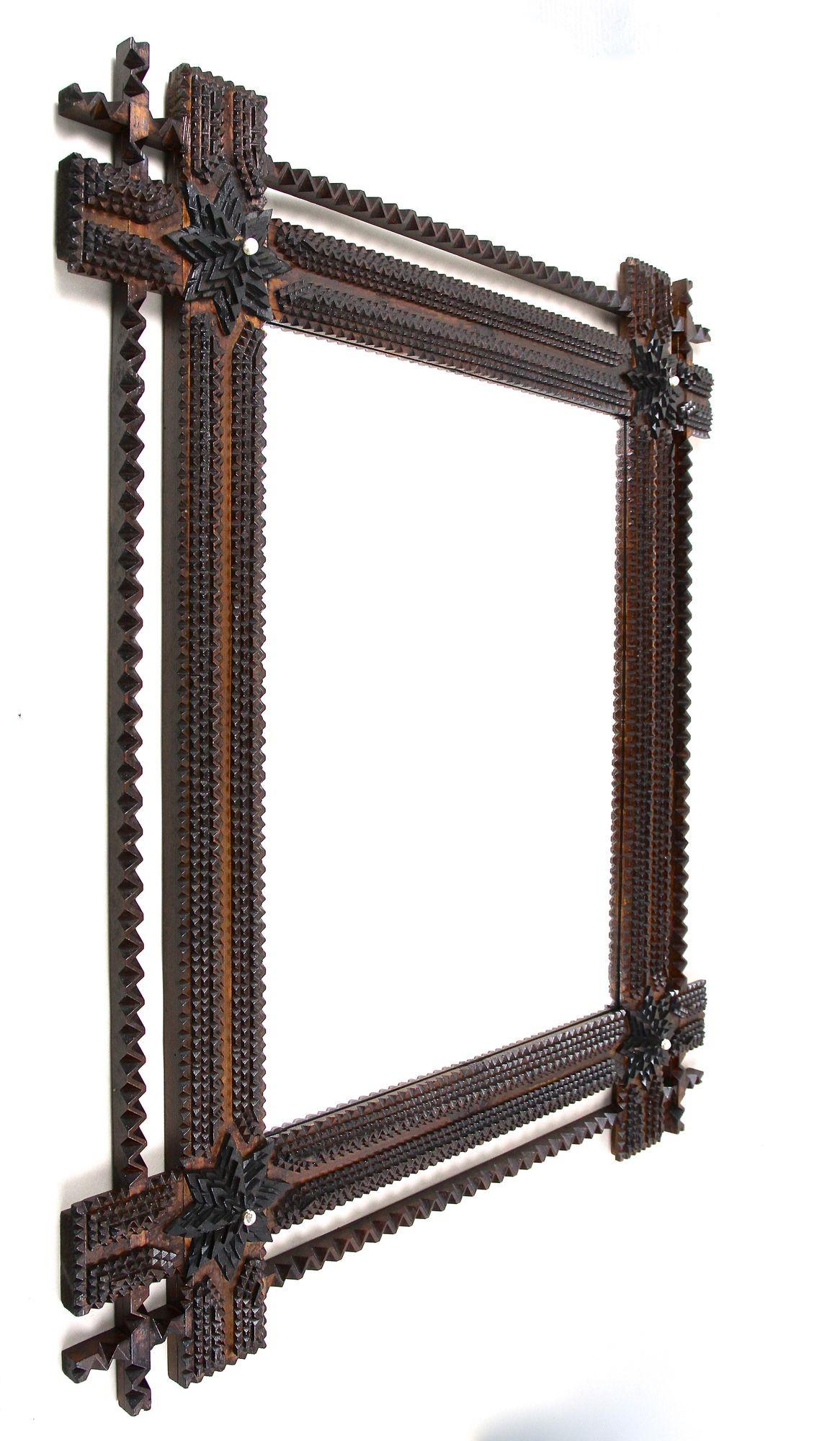 Specchio Tramp Art assolutamente spettacolare, risalente all'inizio del XX secolo in Austria. Elaboratamente intagliato a mano in legno di tiglio intorno al 1900, questo specchio da parete rustico dall'aspetto incredibile è dotato di angoli
