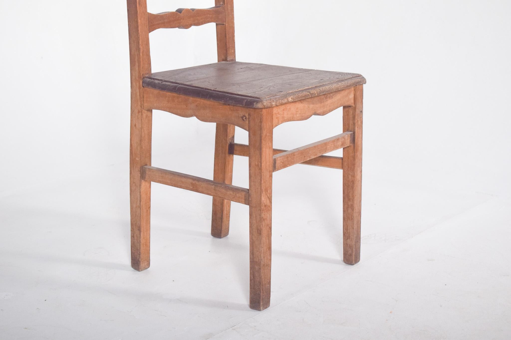 Sedia rustica in legno. Struttura semplice e robusta, che evoca i mobili tradizionali portoghesi. Il retro è costituito da tre traverse orizzontali tagliate con linee curve e simmetriche, che conferiscono leggerezza all'insieme. La seduta, anch'essa