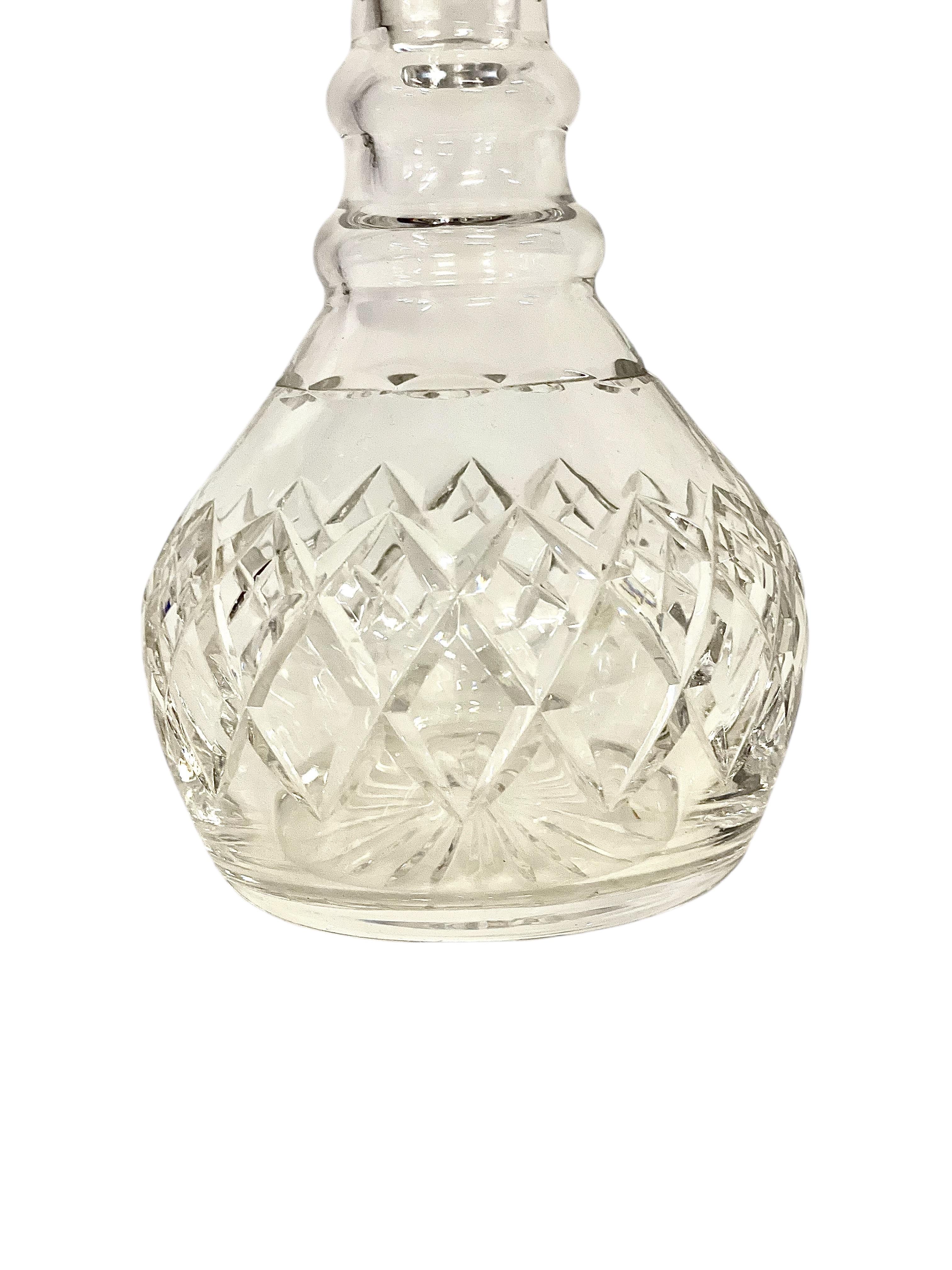 Cette exquise carafe en cristal français est un exemple étonnant de l'artisanat du début du XXe siècle. Cette pièce élégante dégage une beauté intemporelle. Sa forme classique, avec un col subtilement incurvé et un corps en forme de poire, est