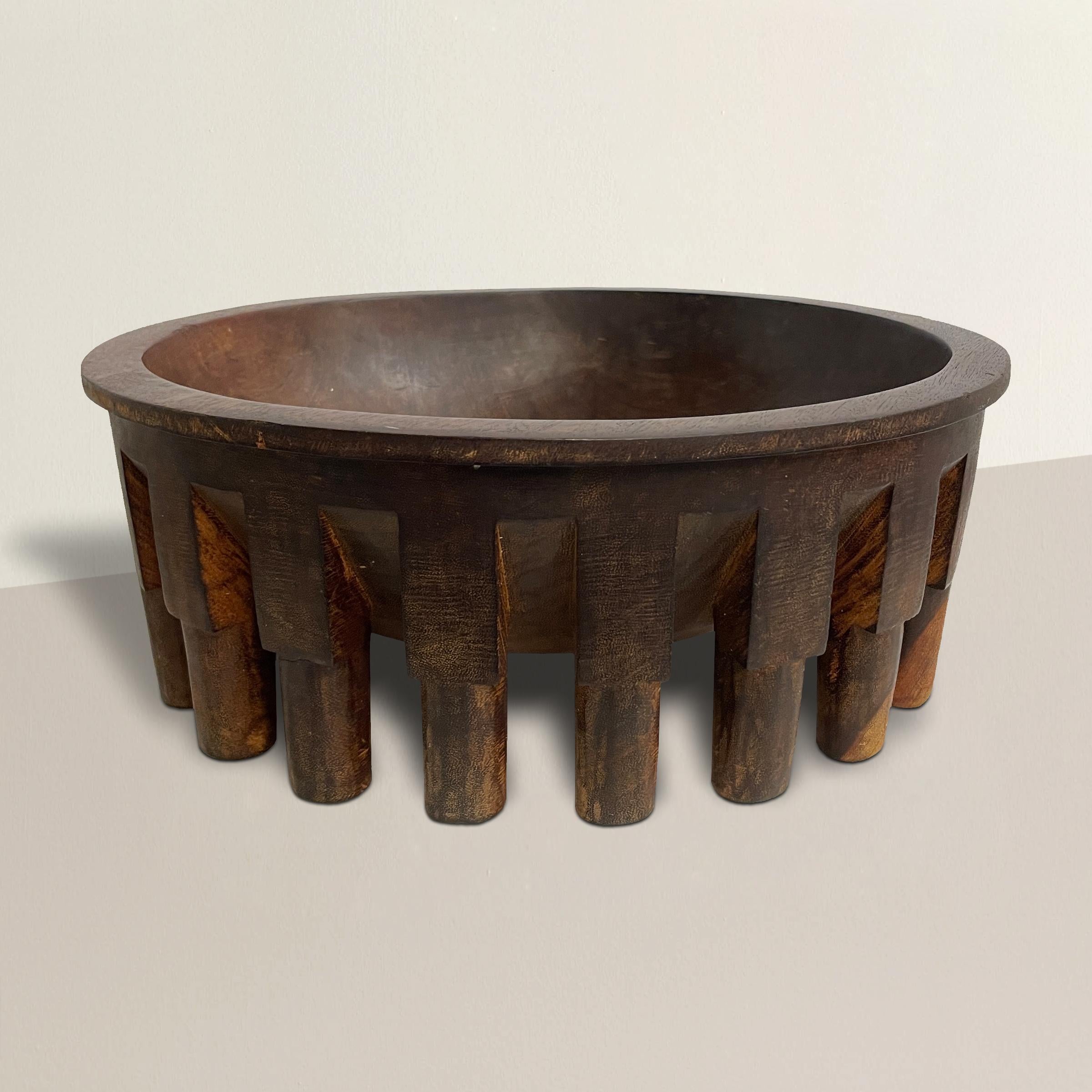 A large 20th Century Samoan circular wooden kava bowl called a tanoa fai'ava and carved from a single piece of wood, standing on twenty round legs, and a hole on one side that was originally used for hanging when not in use.

Kava bowls are used