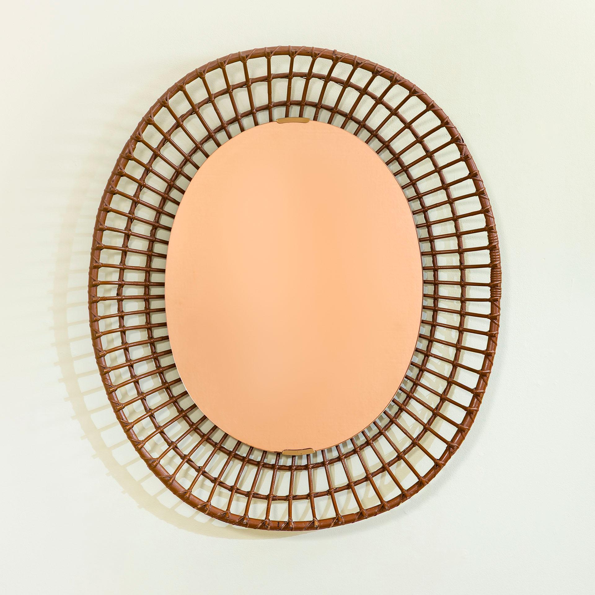 Here we have this wonderful wall mirror with rattan structure, brass details and colored mirrored glass, designed and produced by Santambrogio & De Berti in 1960 circa. 
The mirror is perfect for your vacation house, or for make more summer at your