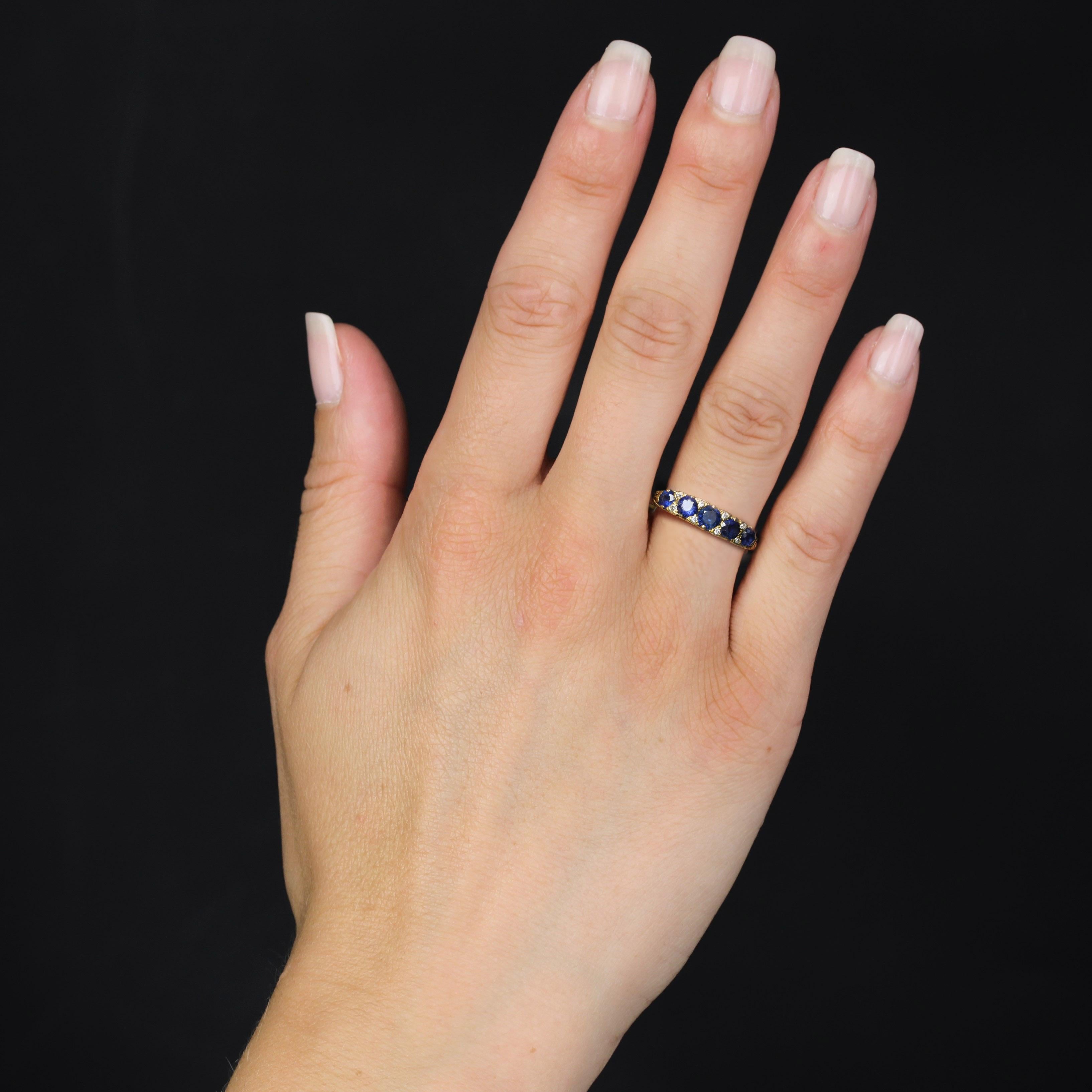 Bague en or jaune 18 carats.
Beau porte-jarretelles ancien, le sommet est orné de 5 saphirs ronds en chute, chacun séparé du saphir précédent par 2 petits diamants taillés en brillant. Les profils de la monture sont ajourés avec des décorations en