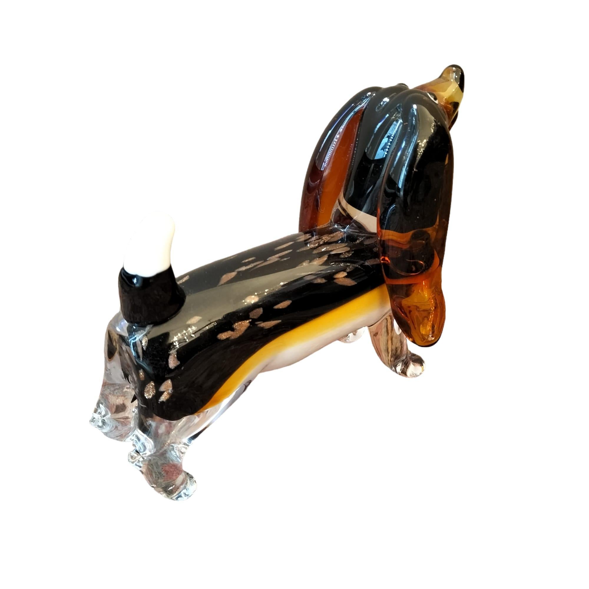 This beautiful animal sculpture, depicting a sausage dog made from Murano glass in vibrant brown hues, was handcrafted in the late 20th century. It bears the signature 'MURANO' discreetly placed on the dog's stomach. The craftsmanship of the glass
