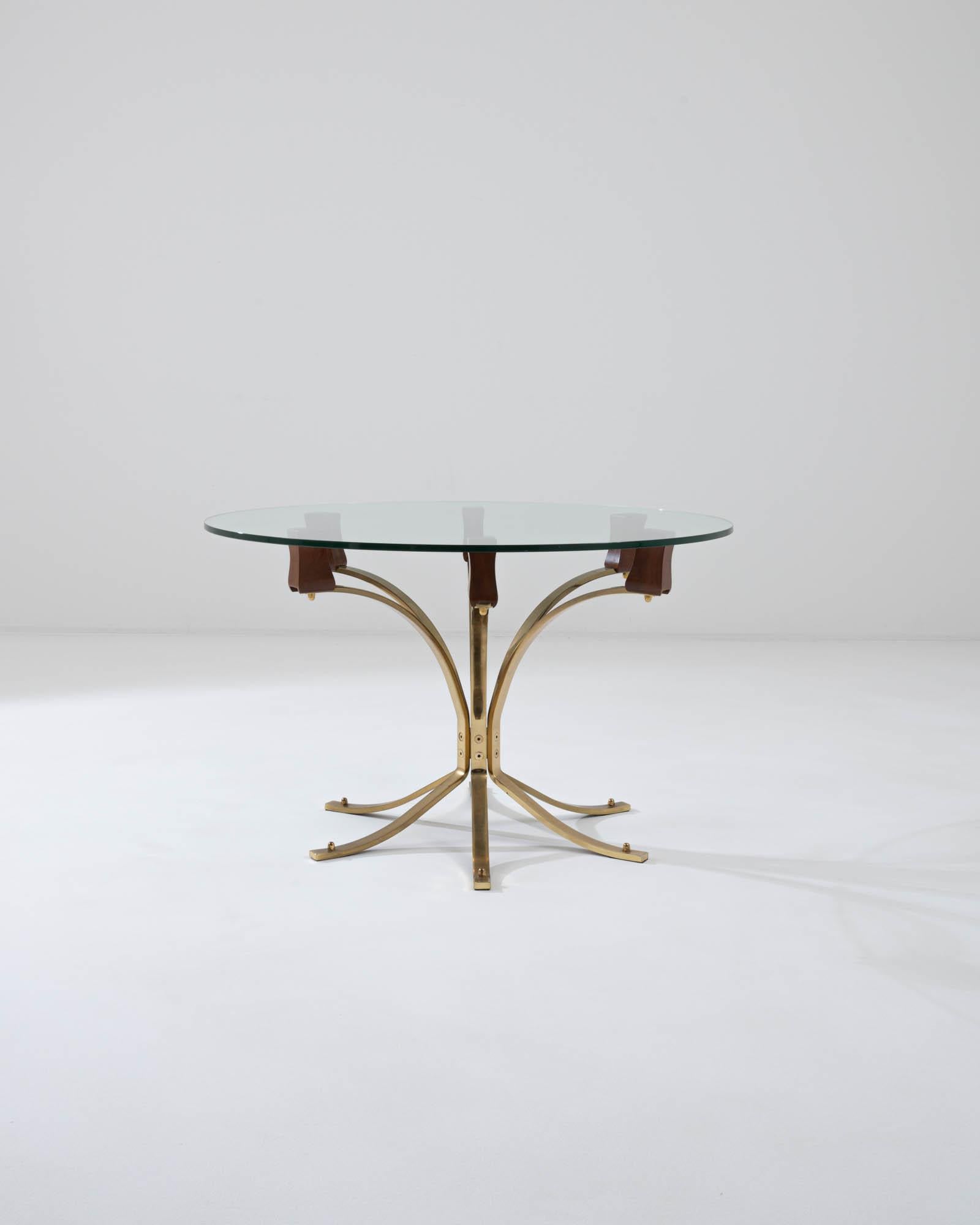 The sophisticated design of this vintage brass side table creates an impression of luxury and precision. Made in Scandinavia in the 20th century, the fanning array of slender brass legs have a mechanical clarity; curved wooden blocks form a bridge