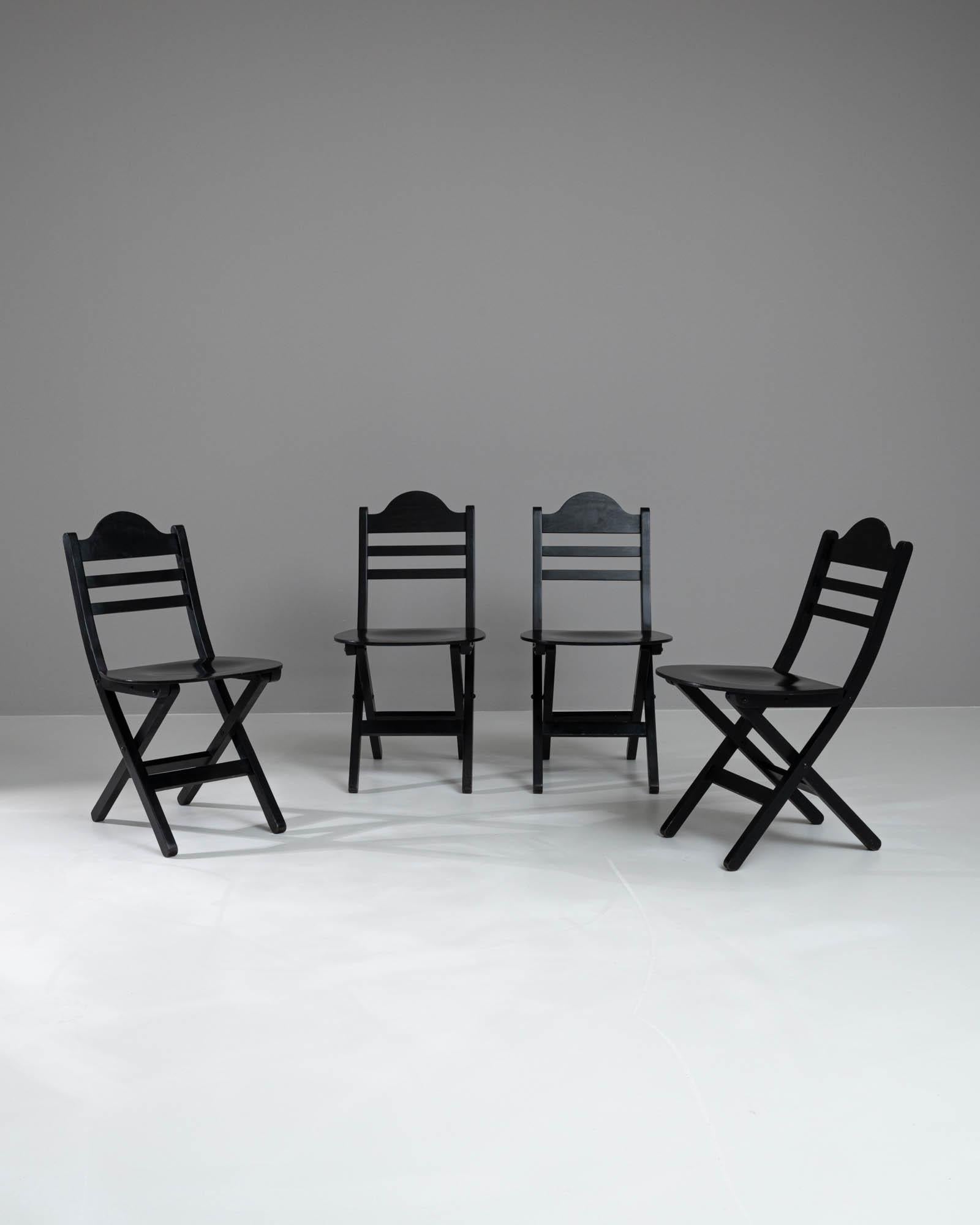 Die zeitlose Eleganz unseres skandinavischen Esszimmerstuhlsets des 20. Jahrhunderts. Dieses Set aus vier Stühlen fügt sich nahtlos in jede Einrichtung ein und versprüht mit seinen klaren Linien und der klassischen schwarzen Oberfläche einen