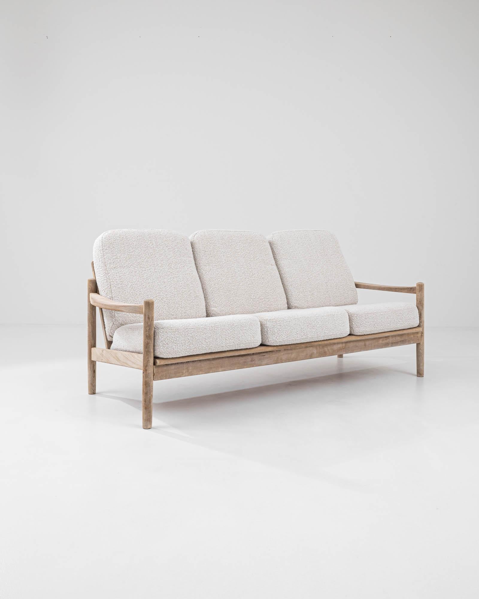 Light and elegant, this vintage wooden sofa epitomizes the homey sophistication of Danish Modern design. Skillfully crafted from fine teak, this mid-century three-seater embodies the essence of the Scandinavian concept of hygge—a feeling of