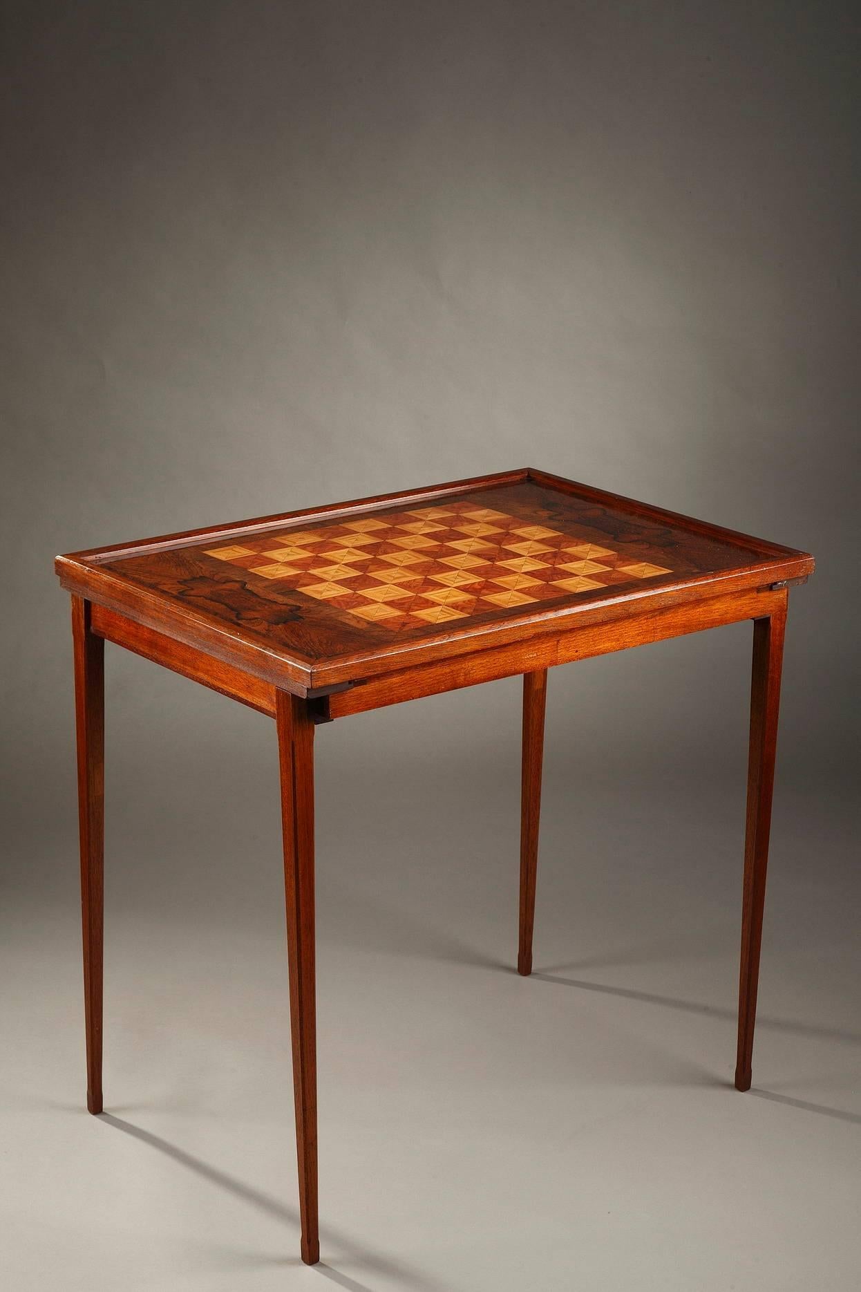 Scandinavian game table from the fifties in rosewood veneer and mahogany, the table top inlaid with central marquetry for playing chess. The sliding top reveals a large drawer inside fitted for games pieces: 60 game pieces for chess and 36 for