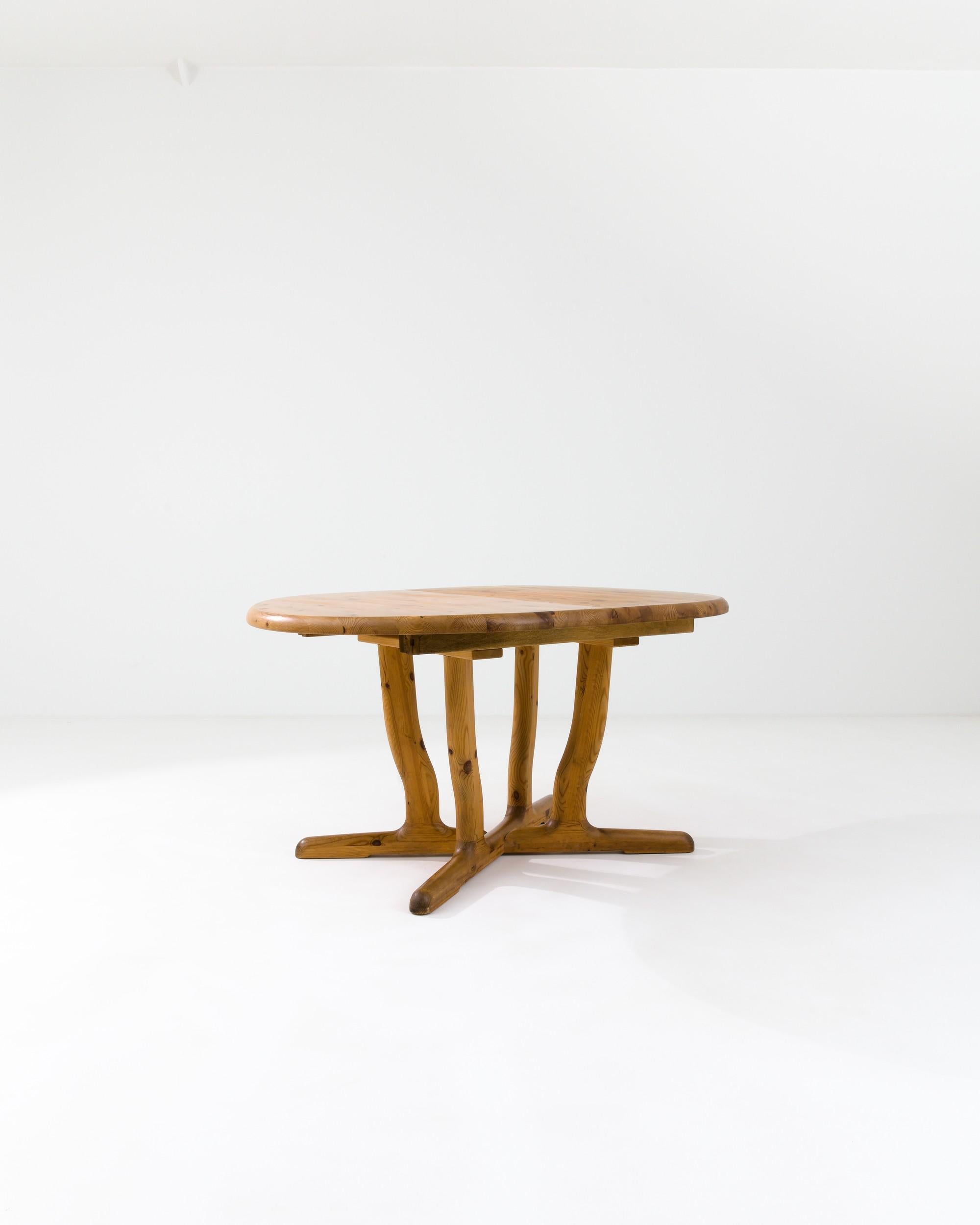 This stylish vintage table, crafted in 20th-century Scandinavia, exudes a sense of fluidity. Its slightly curved legs are enhanced by mesmerizing wood grain naturally ornamented with captivating patterns. Supported by an ‘X’ shaped base, the
