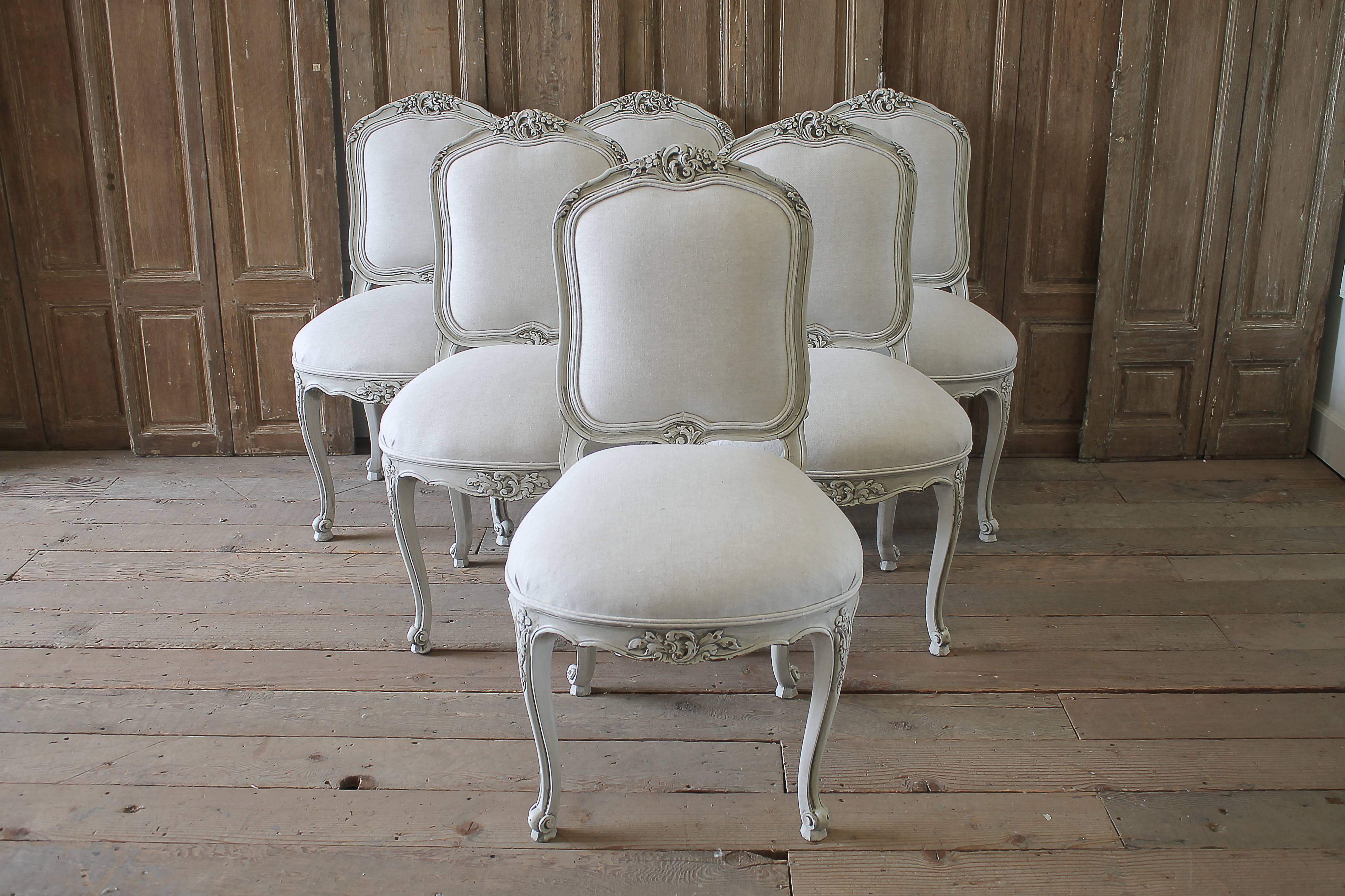 20th century set of six carved French dining chairs upholstered in Belgian linen
Painted in our oyster white, which is a true off-white with subtle distressed edges, and finished with an antique glazed patina.
A cartouche carving with trailing