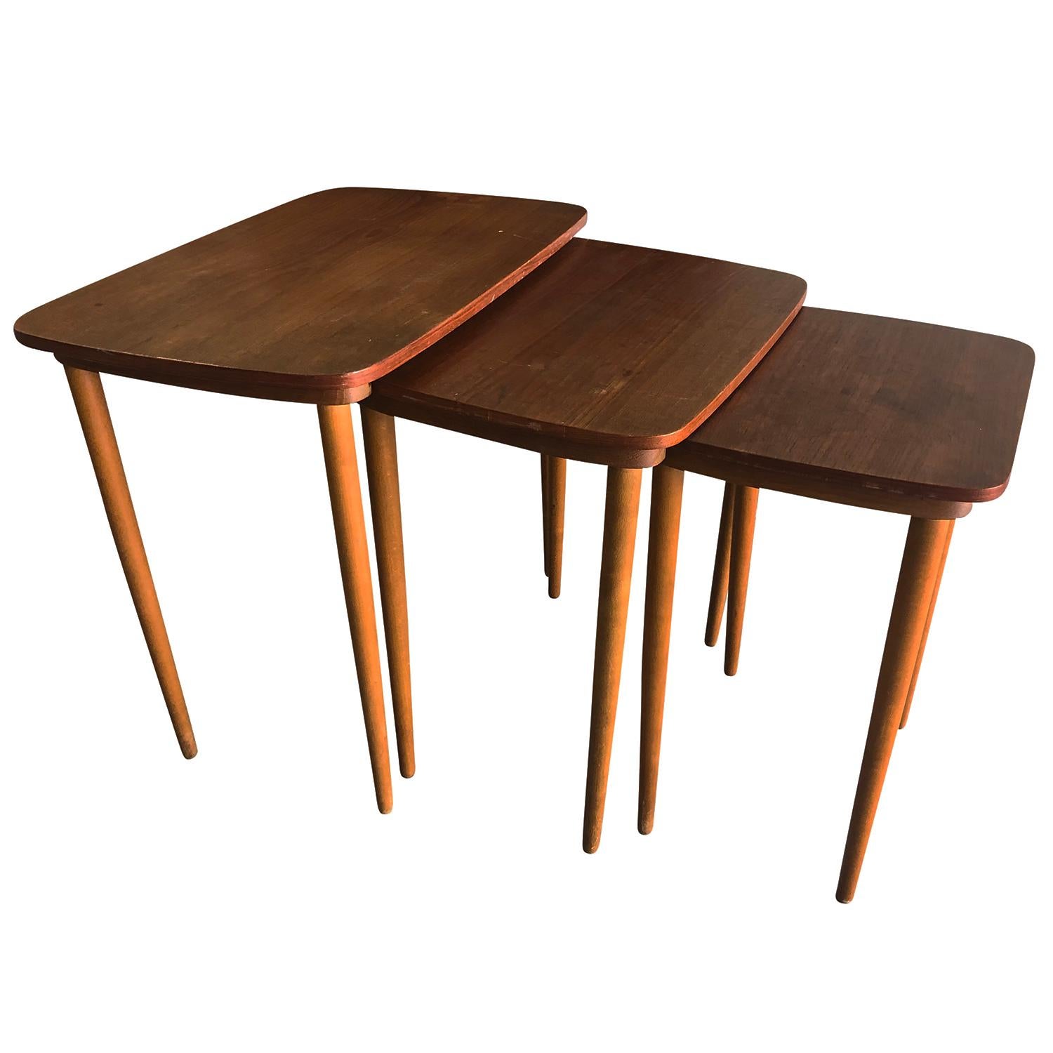 A light-brown, vintage Mid-Century Modern Danish set of three nesting tables made of hand crafted teak and beechwood, in good condition. Wear consistent with age and use, circa 1960, Denmark, Scandinavia.

Measures: Small table 19” H x 14.5” W x
