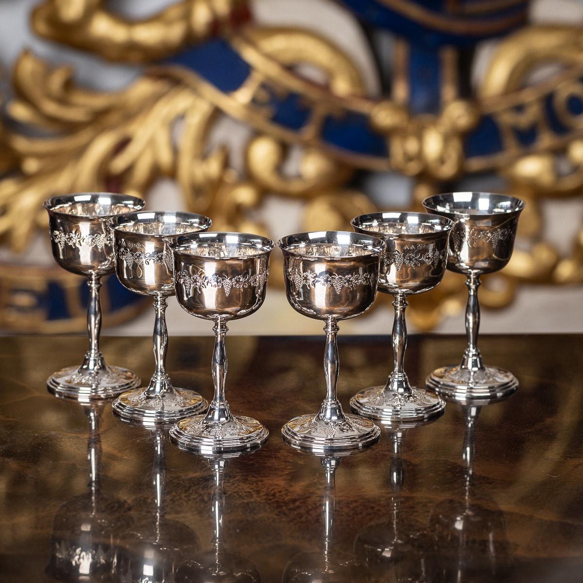 A superb set of six 20th Century English Solid Silver wine goblets. Created by Cavalier in the 1970's, this set of goblets feature a smooth flared drinking rim, leaves & grape vines are engraved in a decorative design around the edge of the goblet