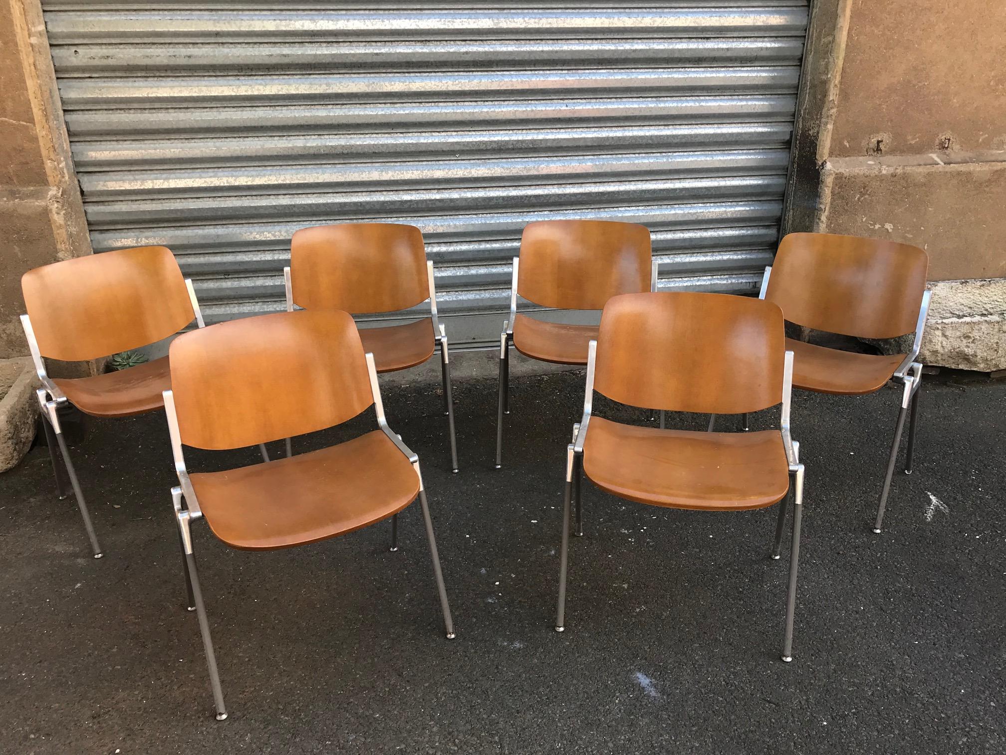 Set of six Mid-Century Modern Giancarlo Piretti DSC conference chairs by Castelli. 
Wooden seat and back and Aluminum base.
These Italian stacking chairs feature carved pressed wood backs and seats stained in a warm tone. 
The sturdy silver tone