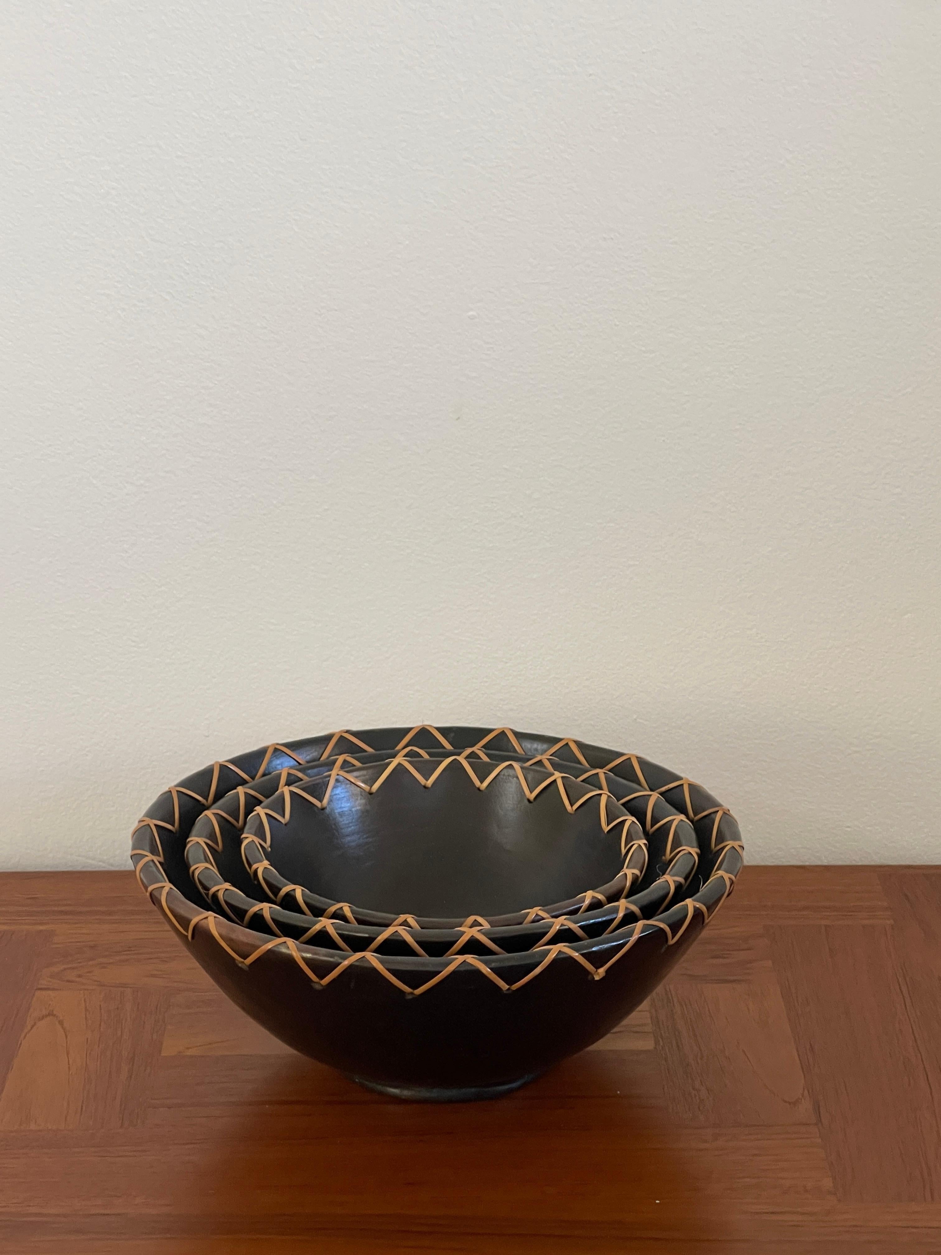 20th Century set of three Indonesian clay bowls made on the island of Lombok. The bowls are put through a heating process that creates a beautiful dark brown color known as 