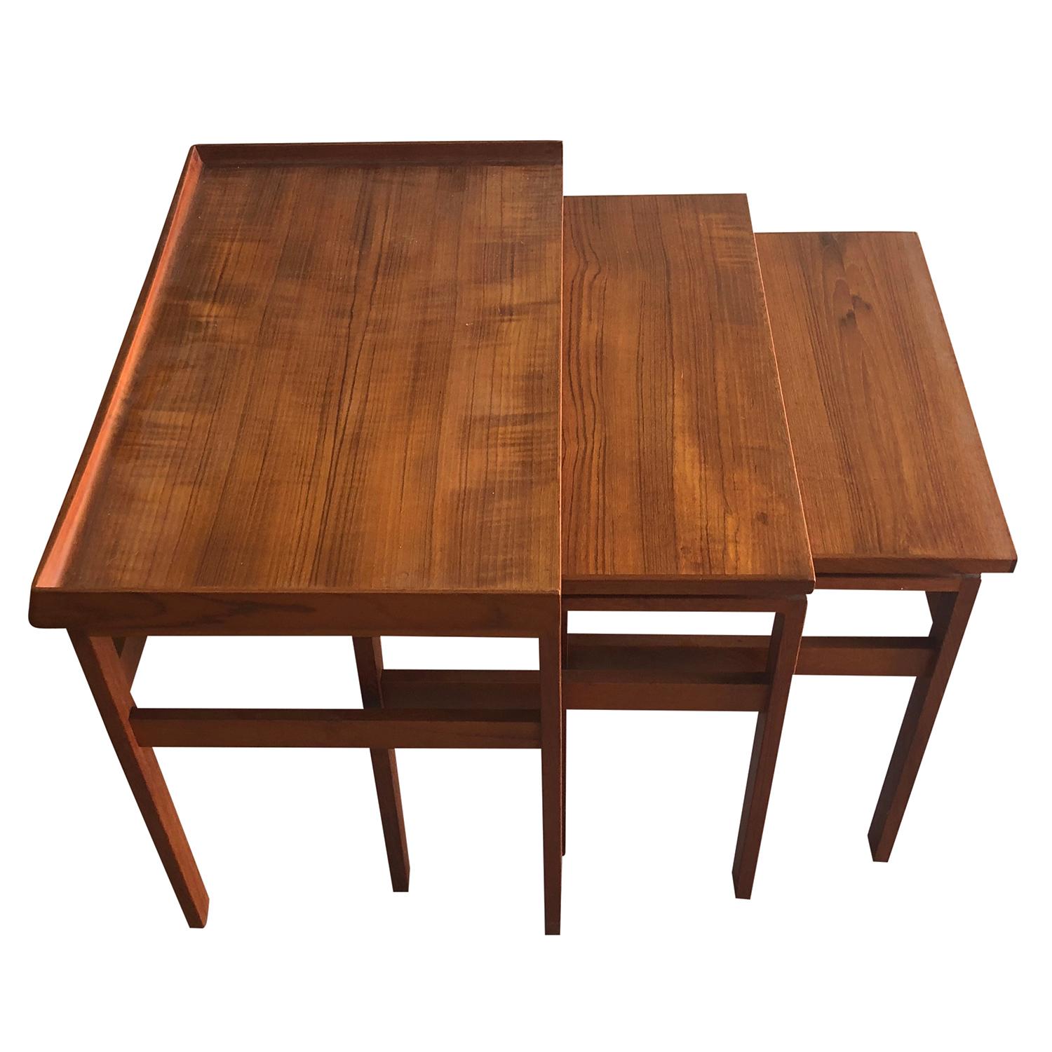 A vintage Mid-Century Modern Danish nest of three side tables made of hand carved teak wood, in good condition. These nest tables with unusual high edges were designed between 1956 and 1960, Denmark. Wear consistent with age and use.

Measures:
