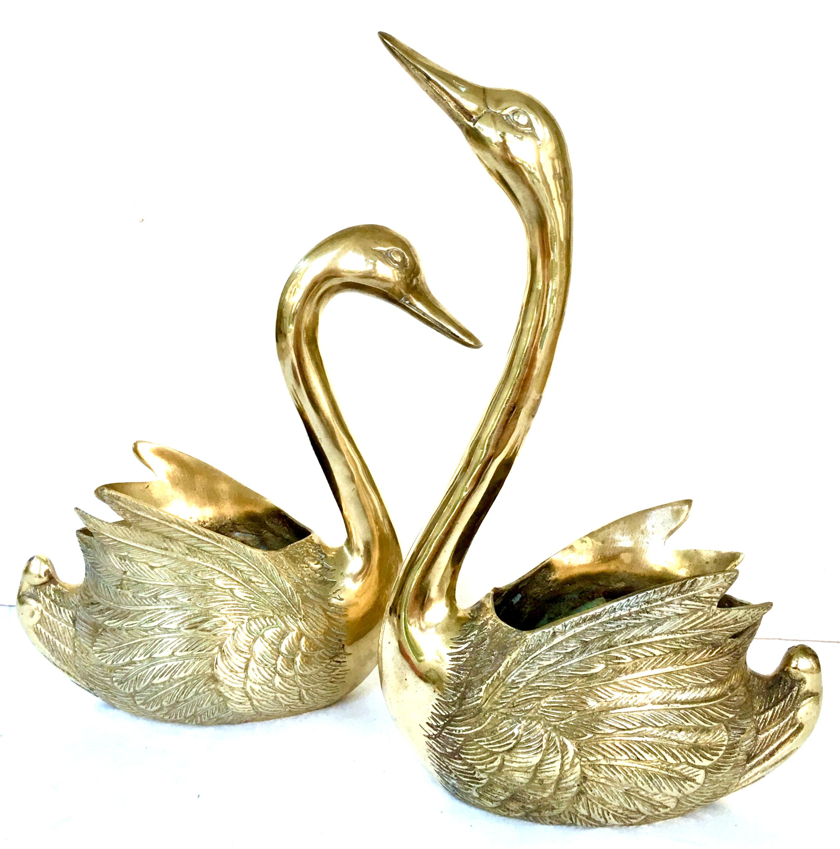 20th century set of two gilt brass etched swan cachepot planter's. This set of two etched gilt brass swan cachepot planters features two sizes.
The smaller swan planter measures: 10.25