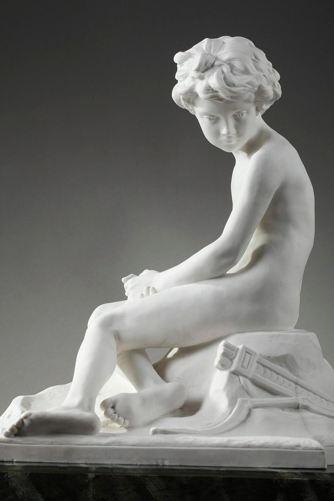 Sèvres porcelain bisque figure depicting L'Amour boudeur (seated cupid) by Alfred Boucher. A young sulky boy, Eros, is sitting on a rock. In classical mythology, Eros or cupid is the god of desire, erotic love, attraction and affection. The