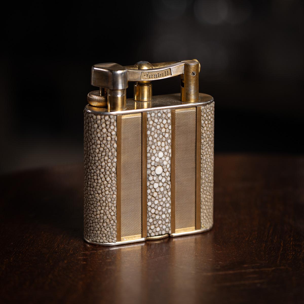 Magnifique briquet de table Dunhill du 20e siècle, présentant des panneaux de dorures tournées alternant avec des sections de galuchat. Estampillé 