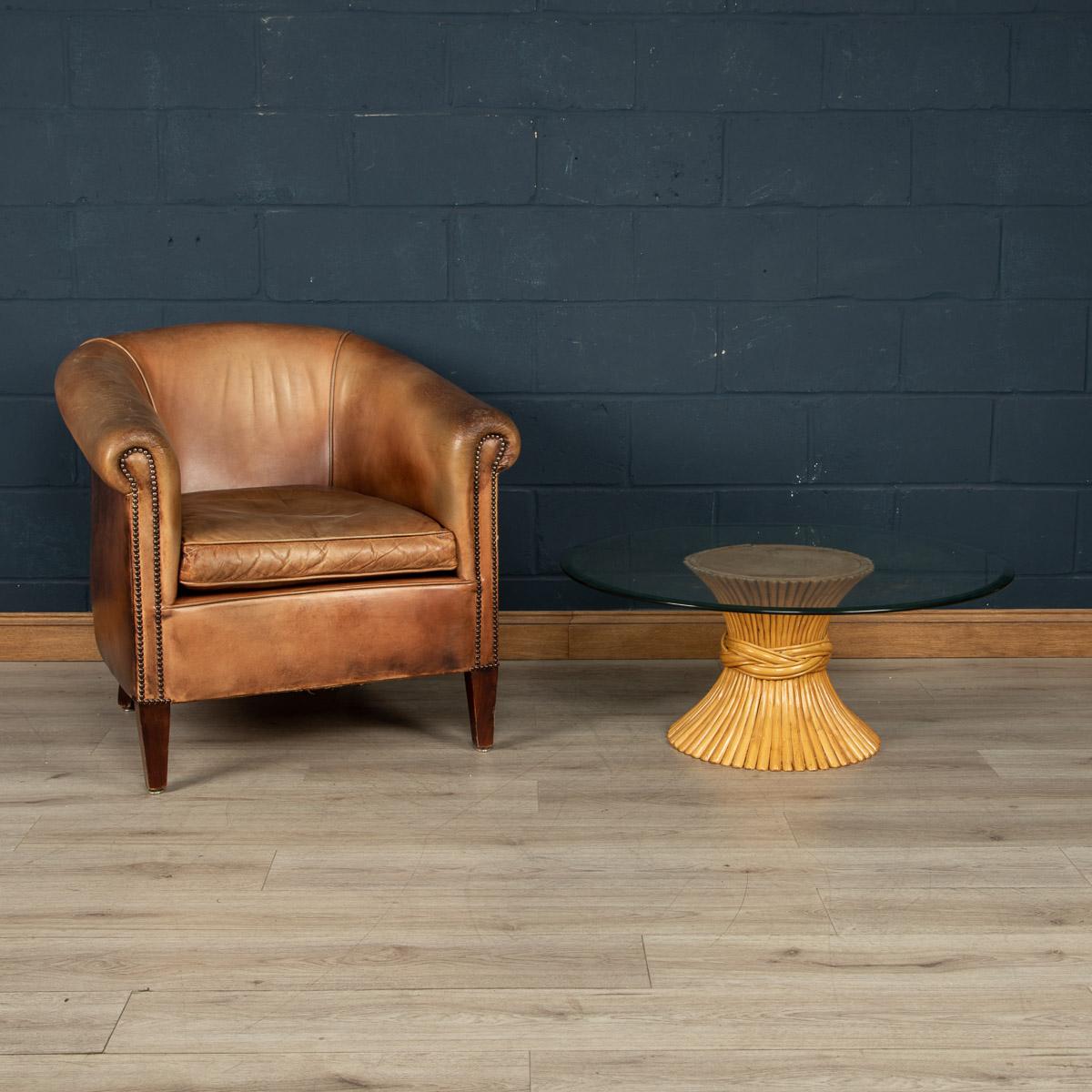 Dating to the latter part of the 20th century, the bamboo frame if shaped like a sheaf of wheat, very typical of McGuire’s work and one of his most popular designs. The table is topped with a round bevelled glass in perfect condition and the base