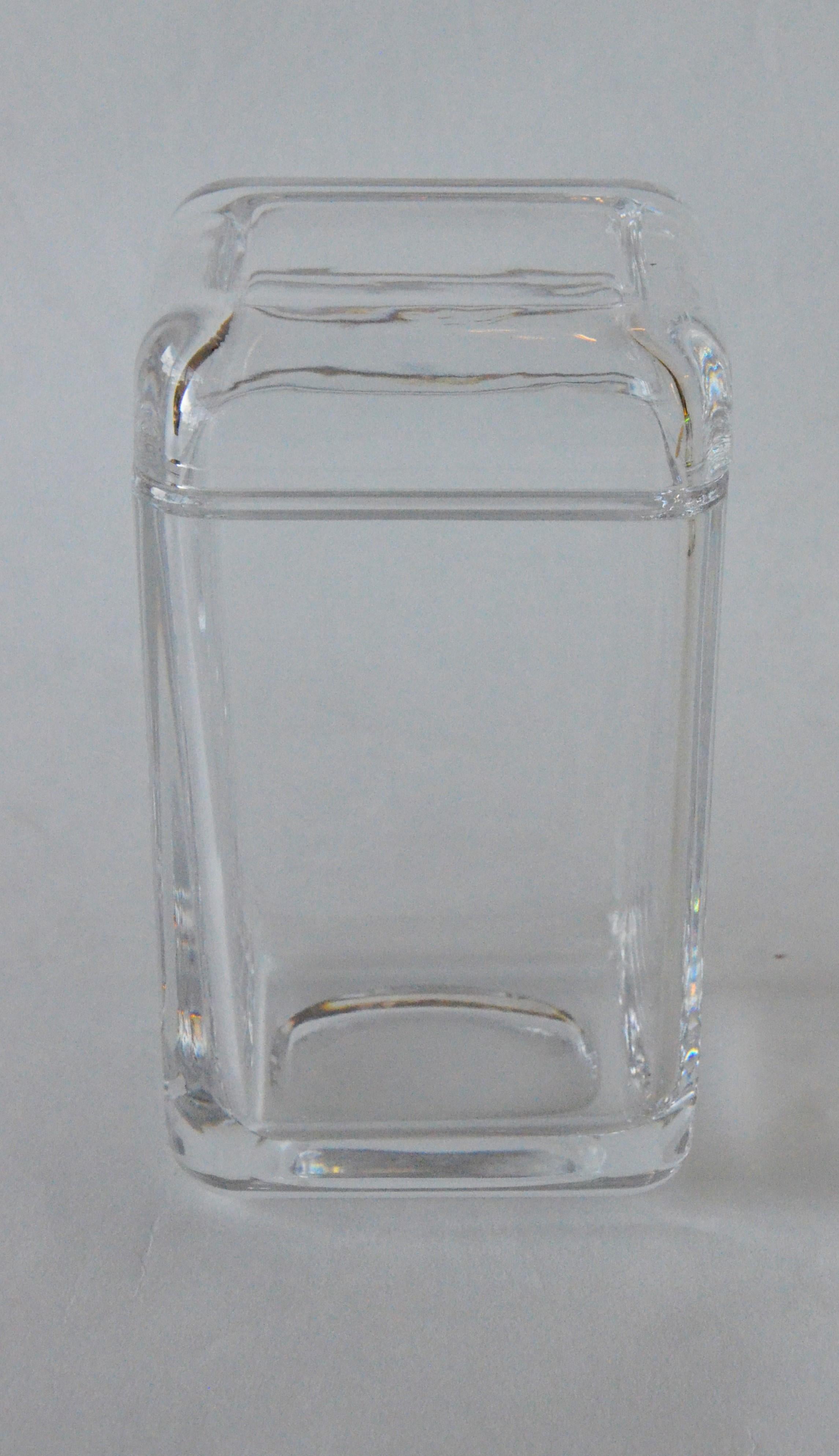 Offered is a late 20th century signed Tiffany & Co. elongated geometric rounded edged rectangular clear glass container / jar with a square glass top. This is a beautiful and quite substantial rectangular glass container with glass square top with