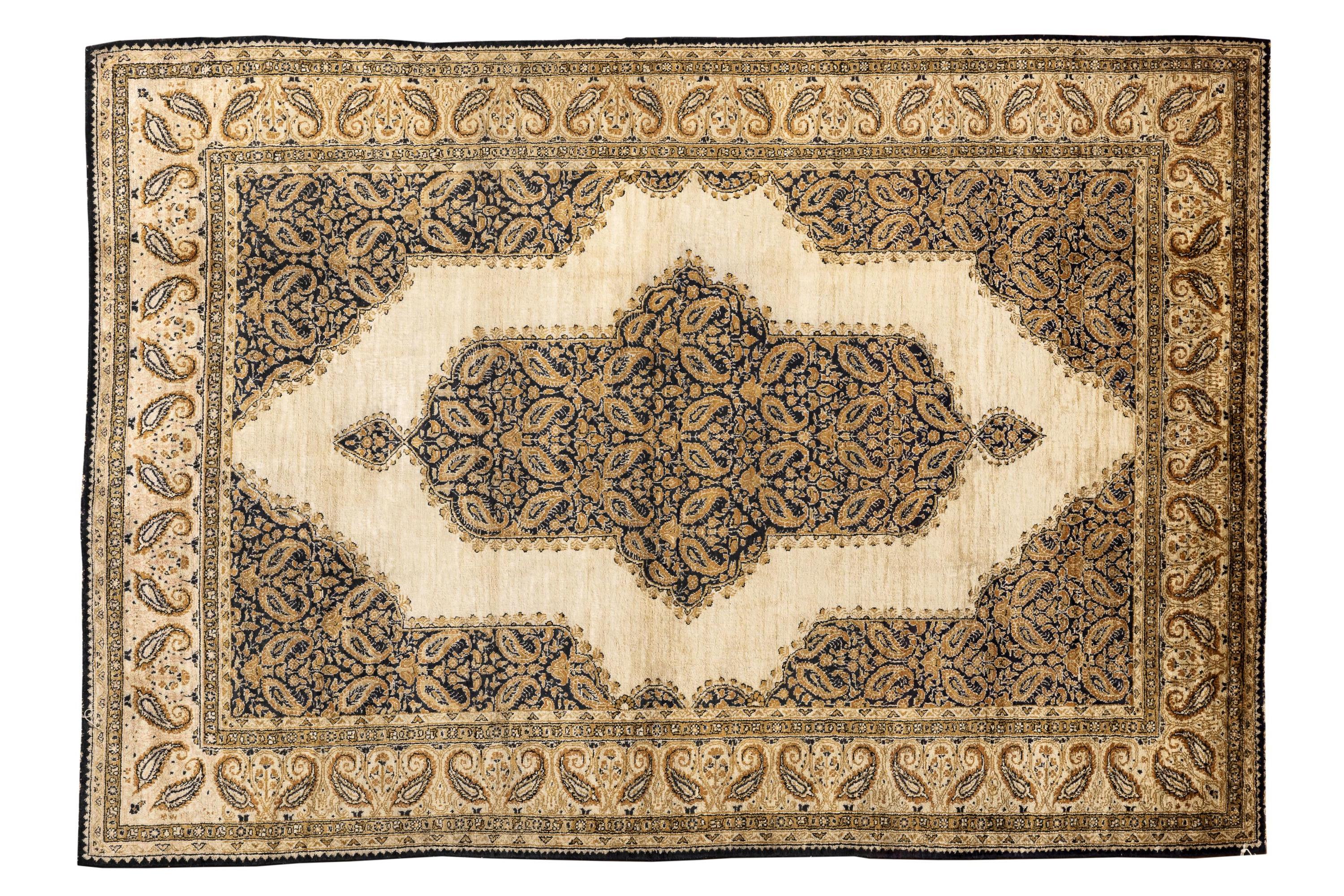 Dieser fein gewebte Seidenteppich präsentiert ein elegantes Zusammenspiel von schimmernden Elfenbein-, tiefen Marine- und warmen Goldtönen, die um ein auffälliges, geschichtetes Medaillon angeordnet sind. Die raffinierten Paisley- und Blumenmotive