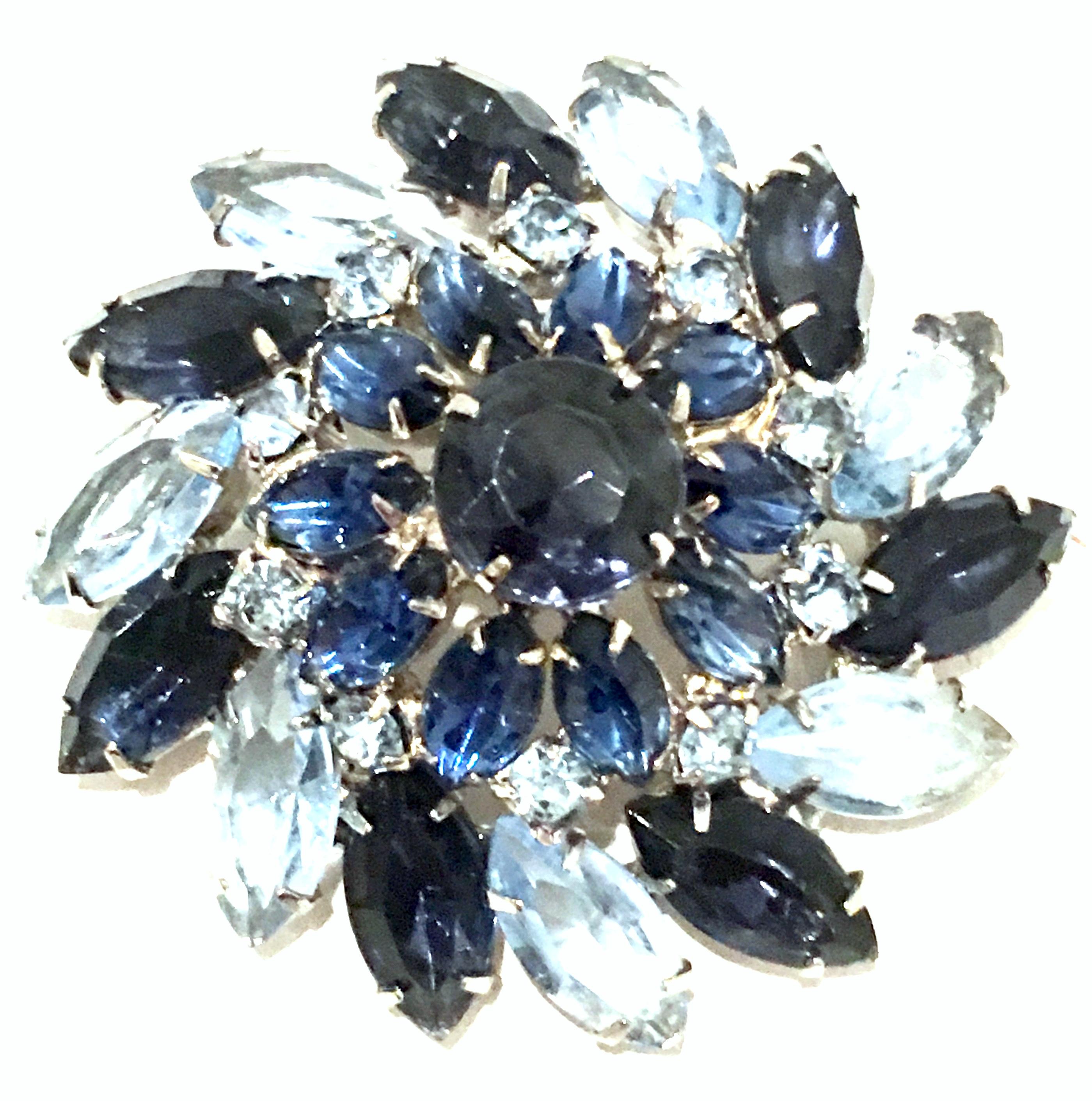 Mid-20th Century Silver Plate & Austrian Crystal Dimensional Abstract Floral Brooch.
This silver rhodium plate brooch features fancy prong set brilliant cut and faceted sapphire blue navette and round stones. The light blue sapphire navette stones