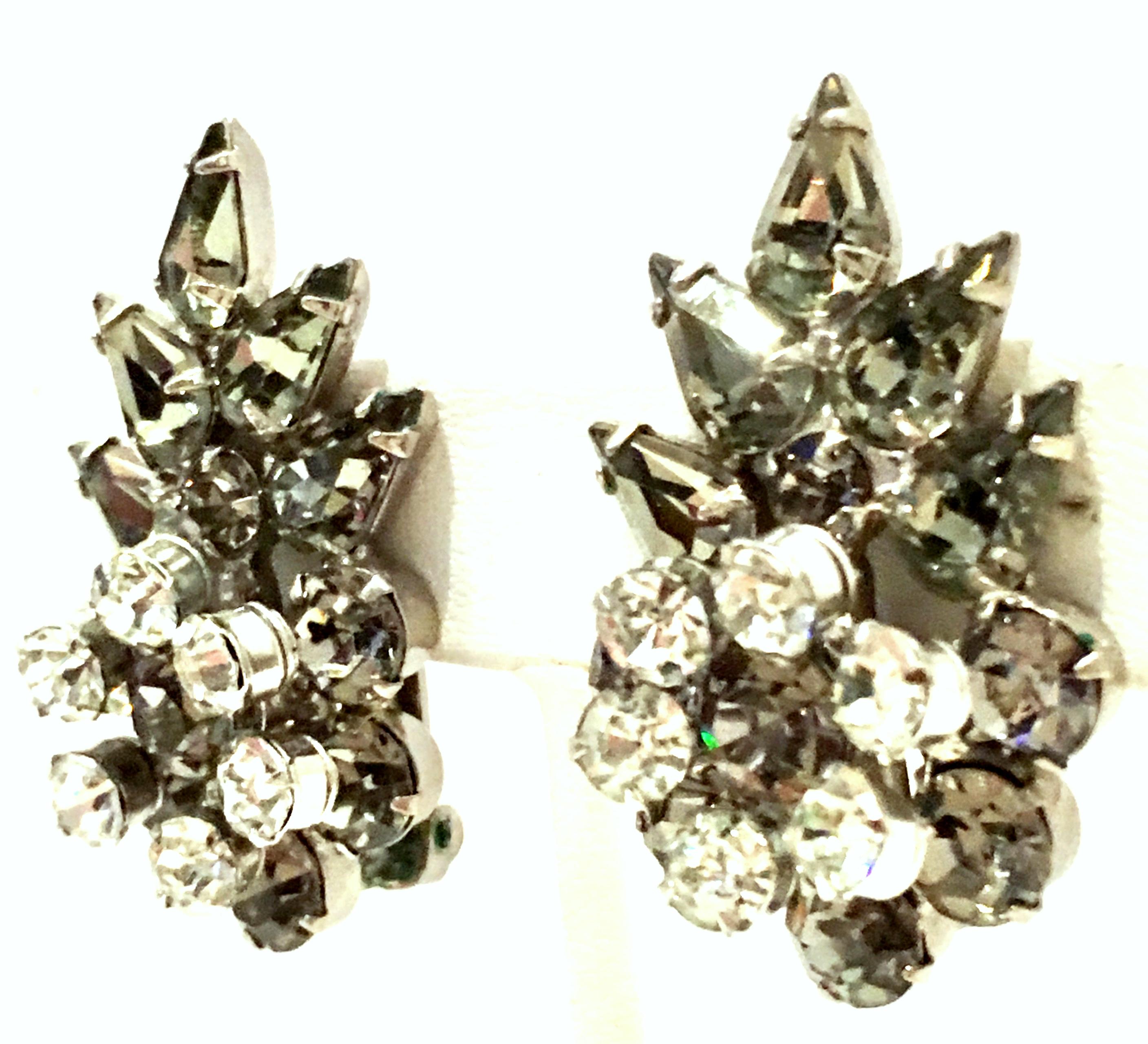 Mid-20th Century Pair Of Silver & Austrian Crystal Dimensional Earrings. These clip style dimensional abstract floral earrings feature silver plate base metal  with brilliant cut and faceted fancy prong set 