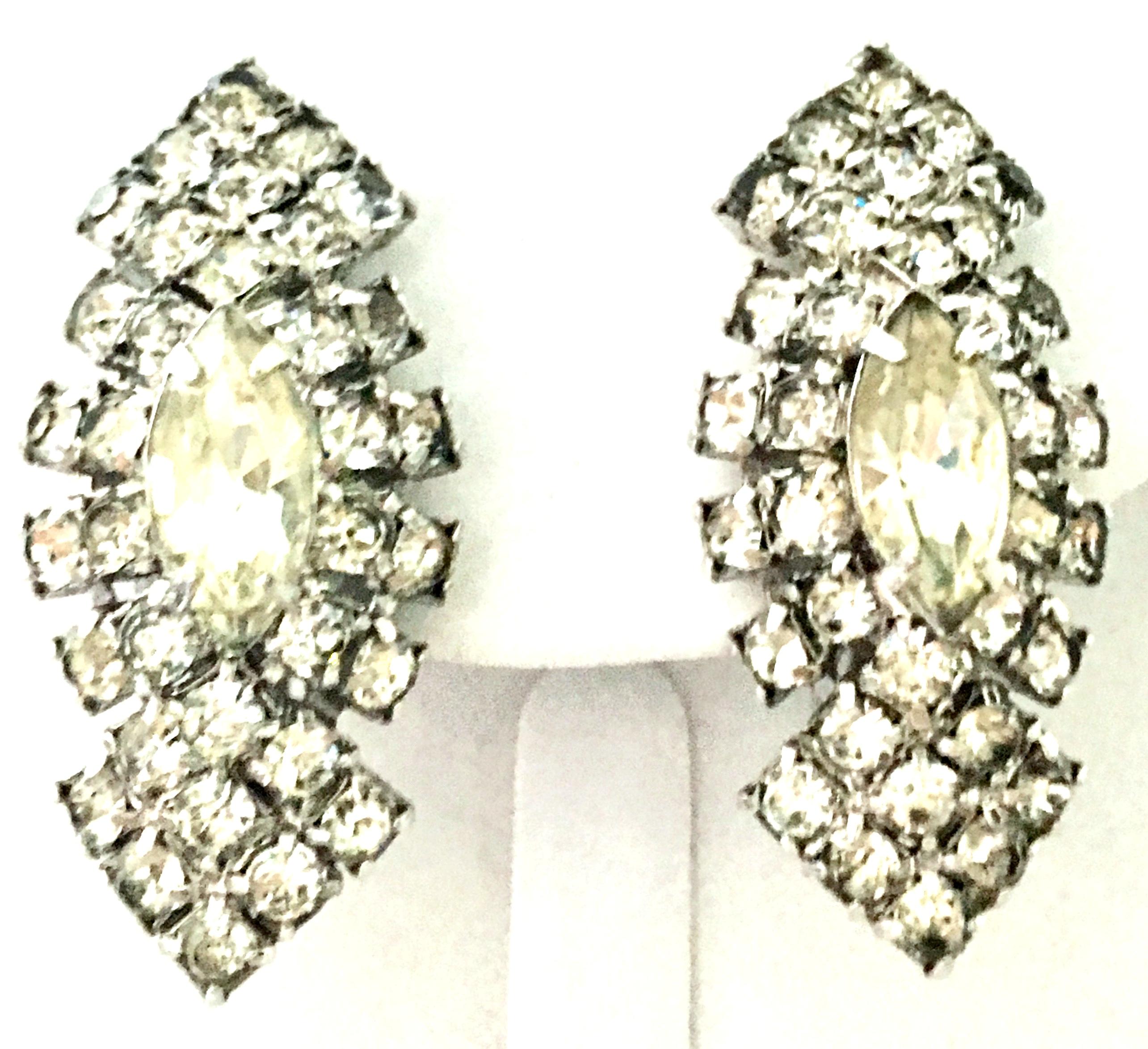 20th Century Silver Plate & Austrian Crystal Earrings. These clip style earrings feature a curved and dimensional shape with prong set, brilliant cut and faceted colorless stones. The large central stone is approximately, .50