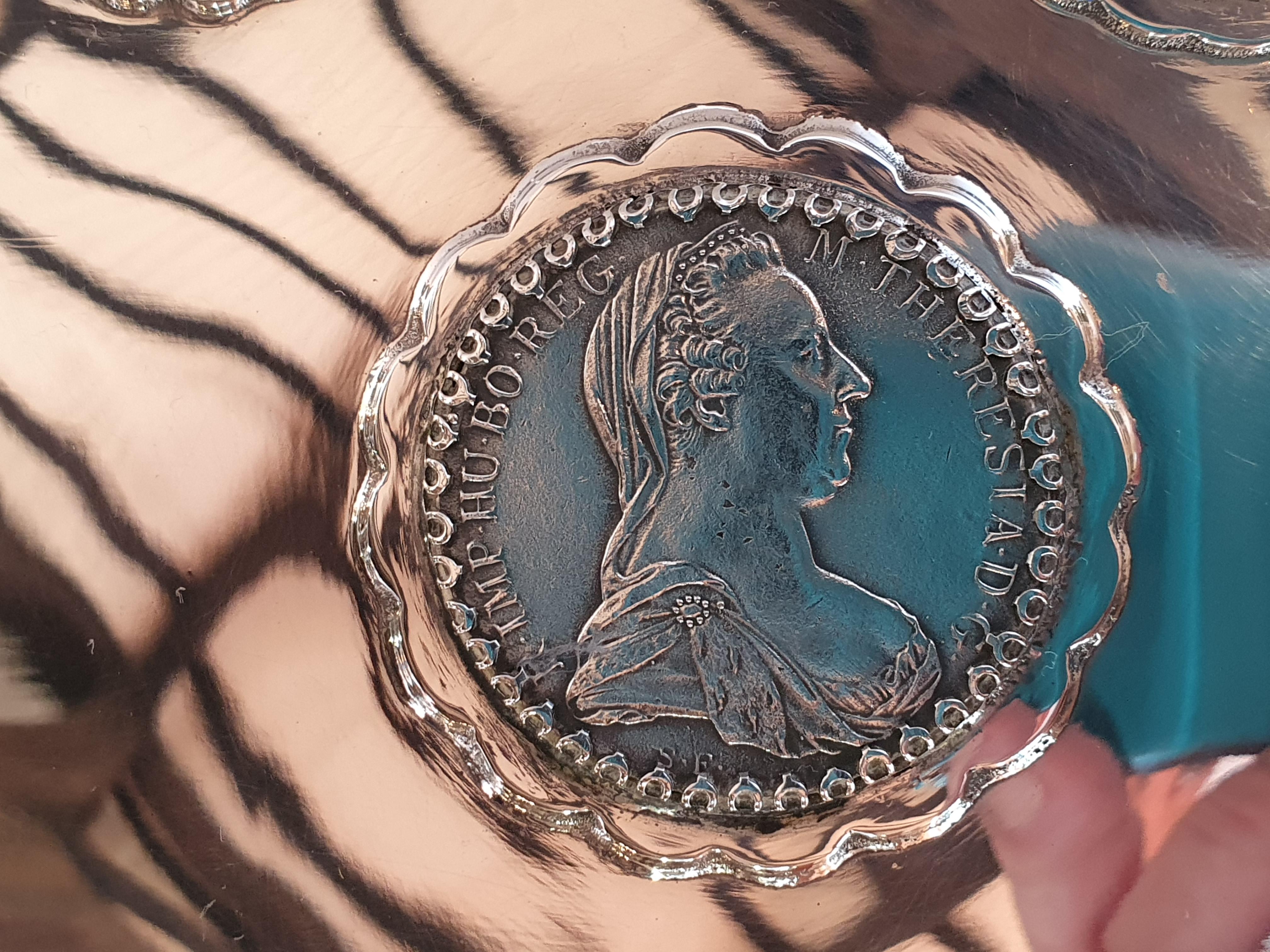 Magnífica caja de plata de ley y madera. En la tapa se han colocado reproducciones de monedas antiguas del Imperio Austrohúngaro.
De hecho, el fabricante de este artículo, Artex, era una sucursal de la Fábrica de la Moneda húngara y empezó su