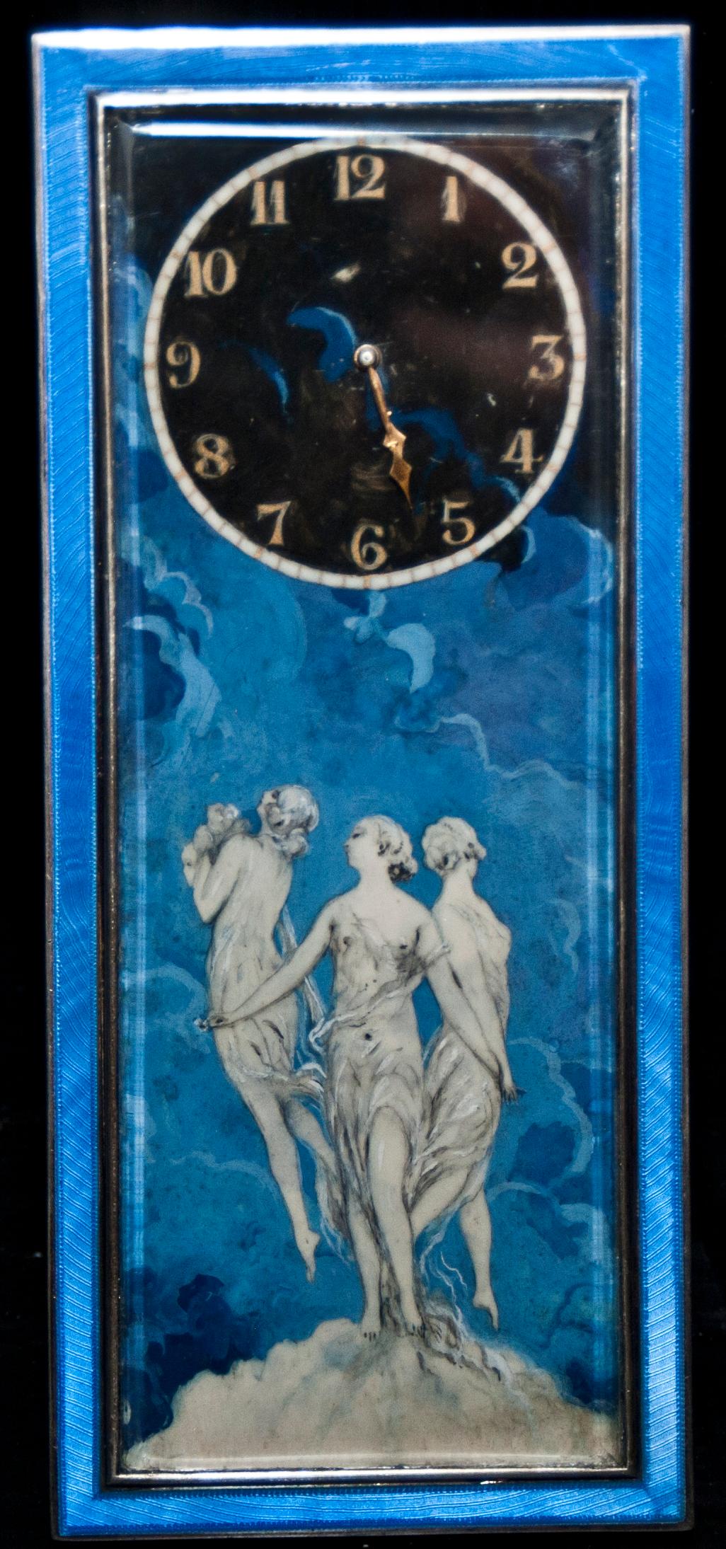 Silver clock painted blue glaze with three Graces in the centre and the clock on the top. The clock is in silver painted with enamels.