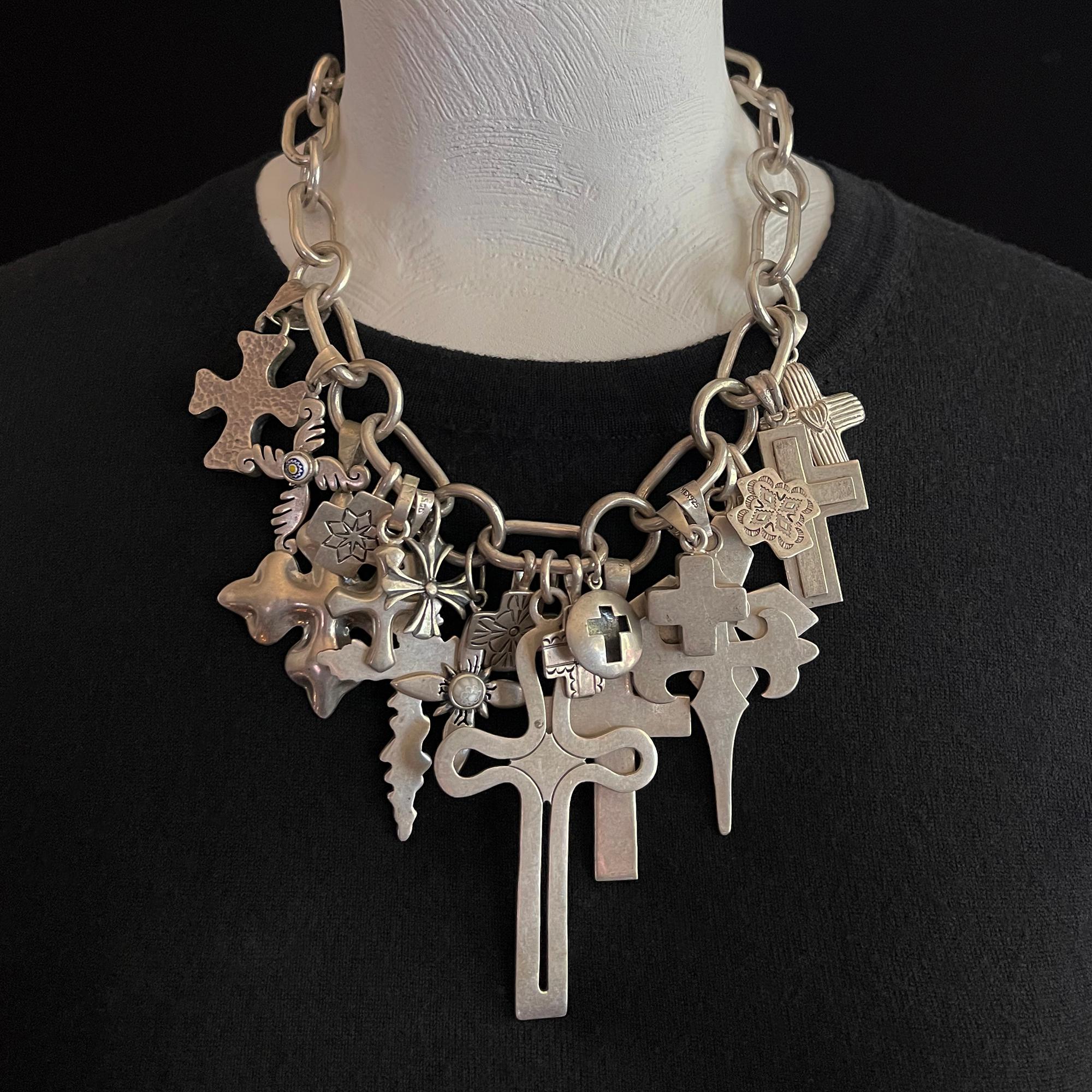 20th century Silver cross necklace by Coreen Cordova of Que Milagros

A dramatic charm necklace designed by Coreen Cordova of Que Milagros containing nineteen interpretations of a cross hanging on thick chainlink, which is finished with a toggle